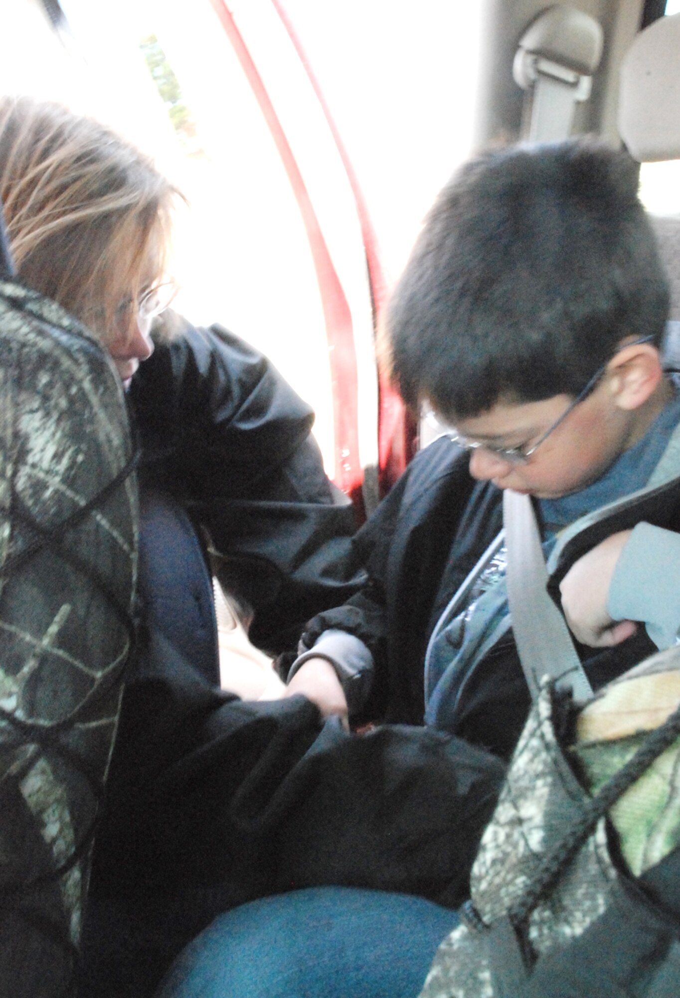 Kelly Burns, Wyoming Highway Patrol, instructs Joshua Palazzo on proper seatbelt position during the child safety seat inspection Saturday at the base family child care office parking lot. Joshua is the son of Master Sgt. Dennis Palazzo, 90th Logistic Readiness Squadron. One thing some children do incorrectly is place the seatbelt too low on their shoulder (U.S. Air Force photo by Staff Sgt. Chad Thompson).