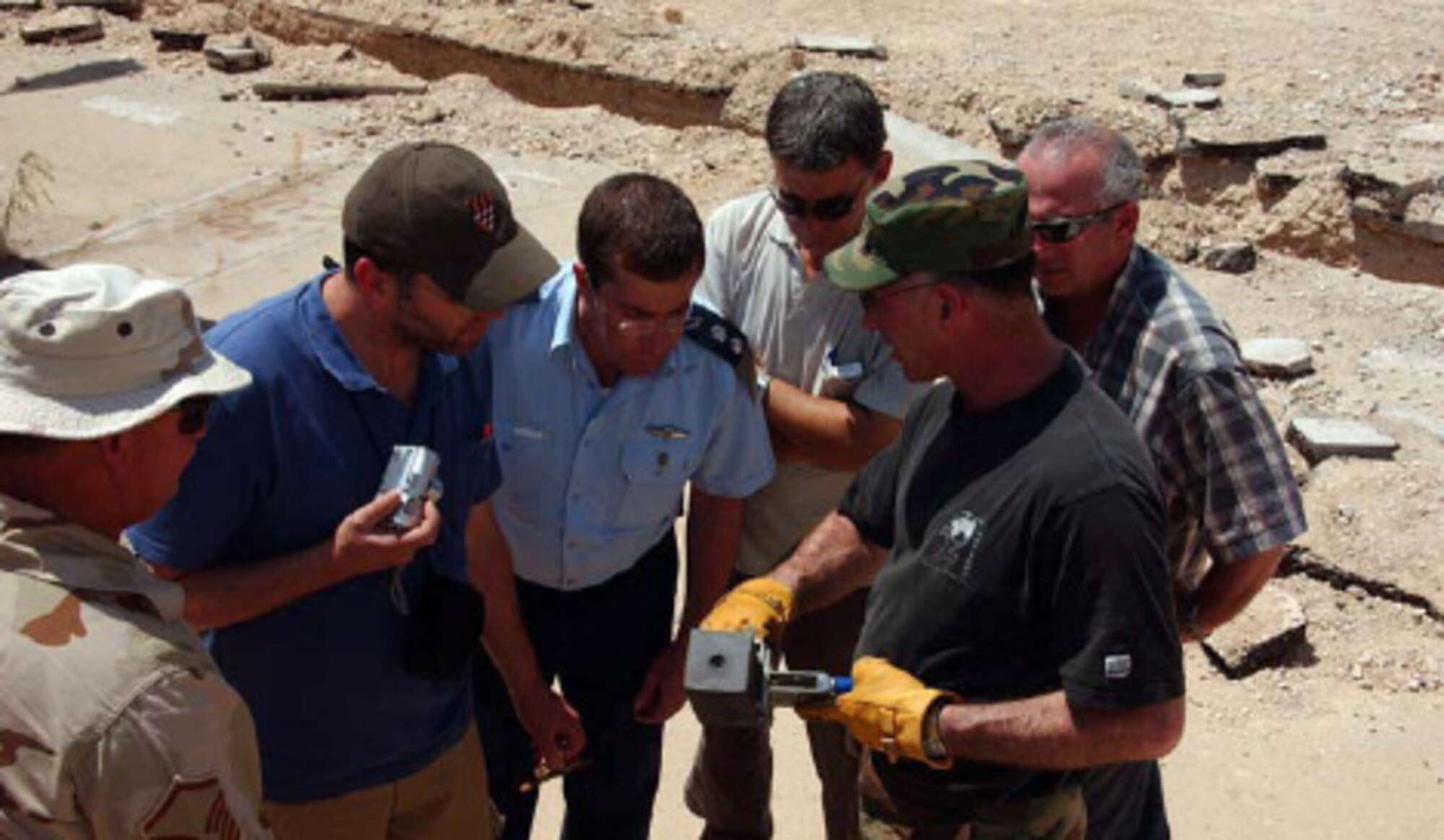 TSgt. John Swearingin of the Alaska Air National Guard trains airmen from the Israeli Air Force on exothermic welding. Swearingin is from Kodiak, Alaska, and has been doing exothermic welding for nearly 15 years. Wearing the blue uniform is Israeli Lt. Col. Ronen Salomon, chief of research & technologies for the Israeli Air Force's Civil Engineering Division. He and the other Israeli airmen will use this information to train other airmen on the technology. Photo by Master Sgt. Julia Barklow