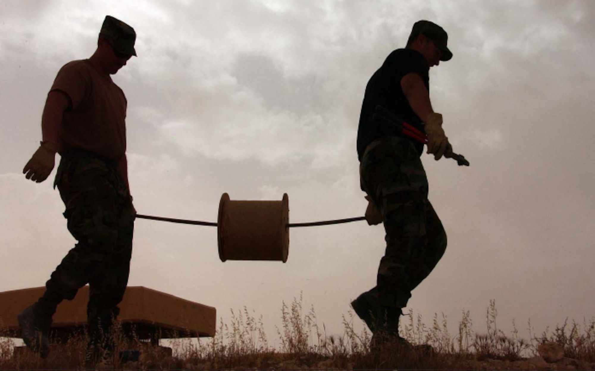 176 CES airmen TSgt. Tom Bradley, left, and SrA. Jason Hart string copper wire as part of a lightning protection system for a munitions bunker.