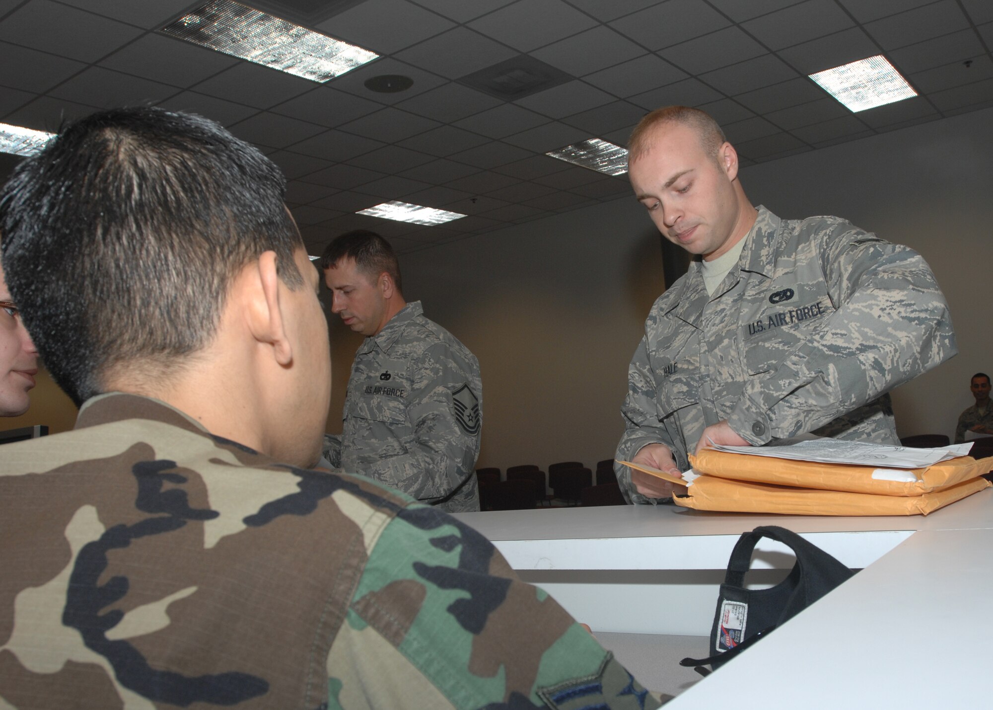 WHITEMAN AIR FORCE BASE, Mo.- Senior Airman James Hale, 509th Logistics Readiness Squadron, in-processes with Airman 1st Class David Redona, 509th Medical Operations Squadron, at the Whiteman Deployment Center April 14. Airman Hale is returning from his deployment to Southeast Asia as the lead convoy driver with 424th Medium Truck Detachment. (U.S. Air Force photo/Tech. Sgt. Samuel A. Park)