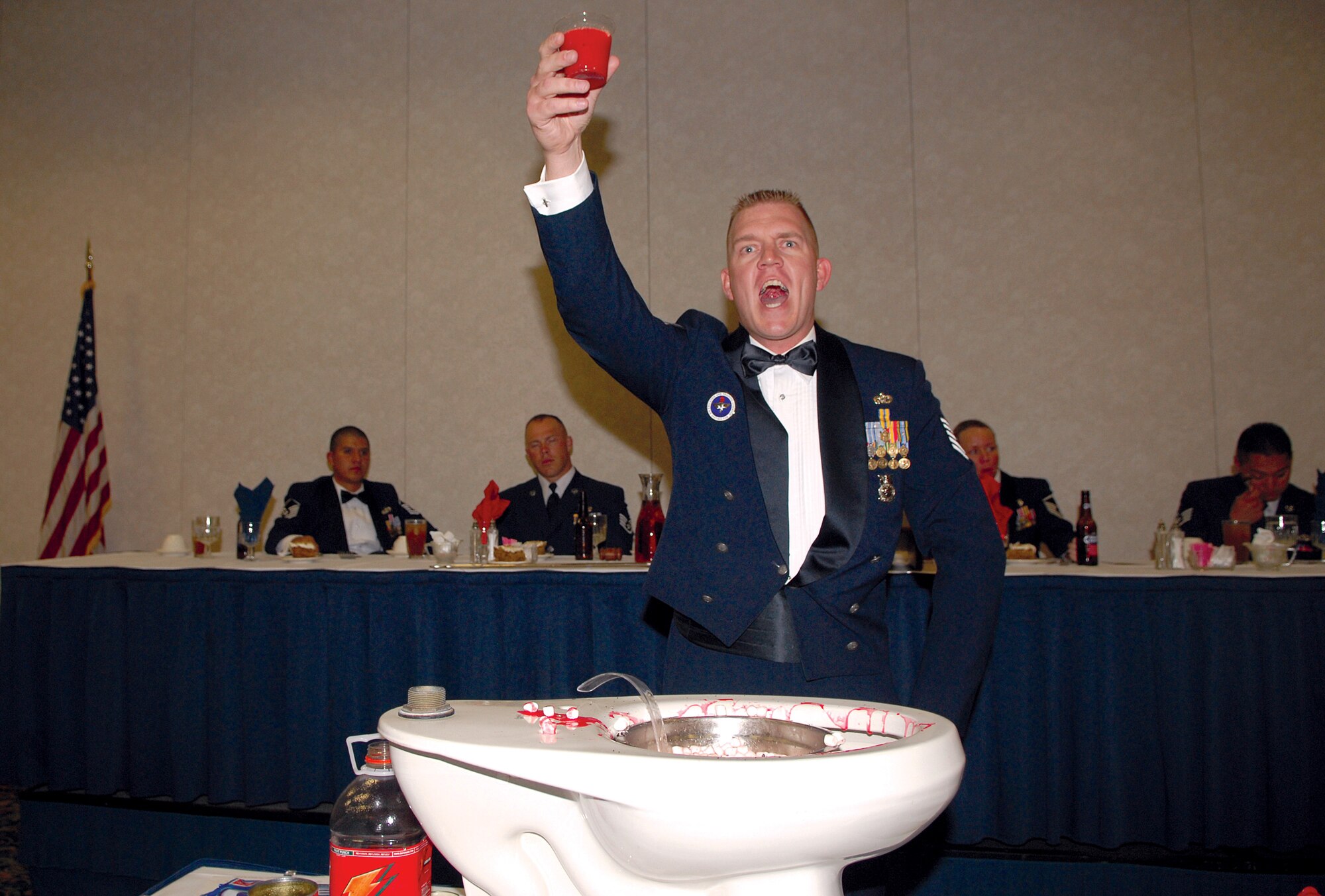 “To the Mess!” shouts Tech. Sgt. Gregory Young as he prepares to down a foul beverage known as “the grog.” Violations of the Rules of the Mess are punished with a trip to the grog bowl, a long-standing tradition of dinings-in. (U.S. Air Force photo by Tech. Sgt. Gina O’Bryan)