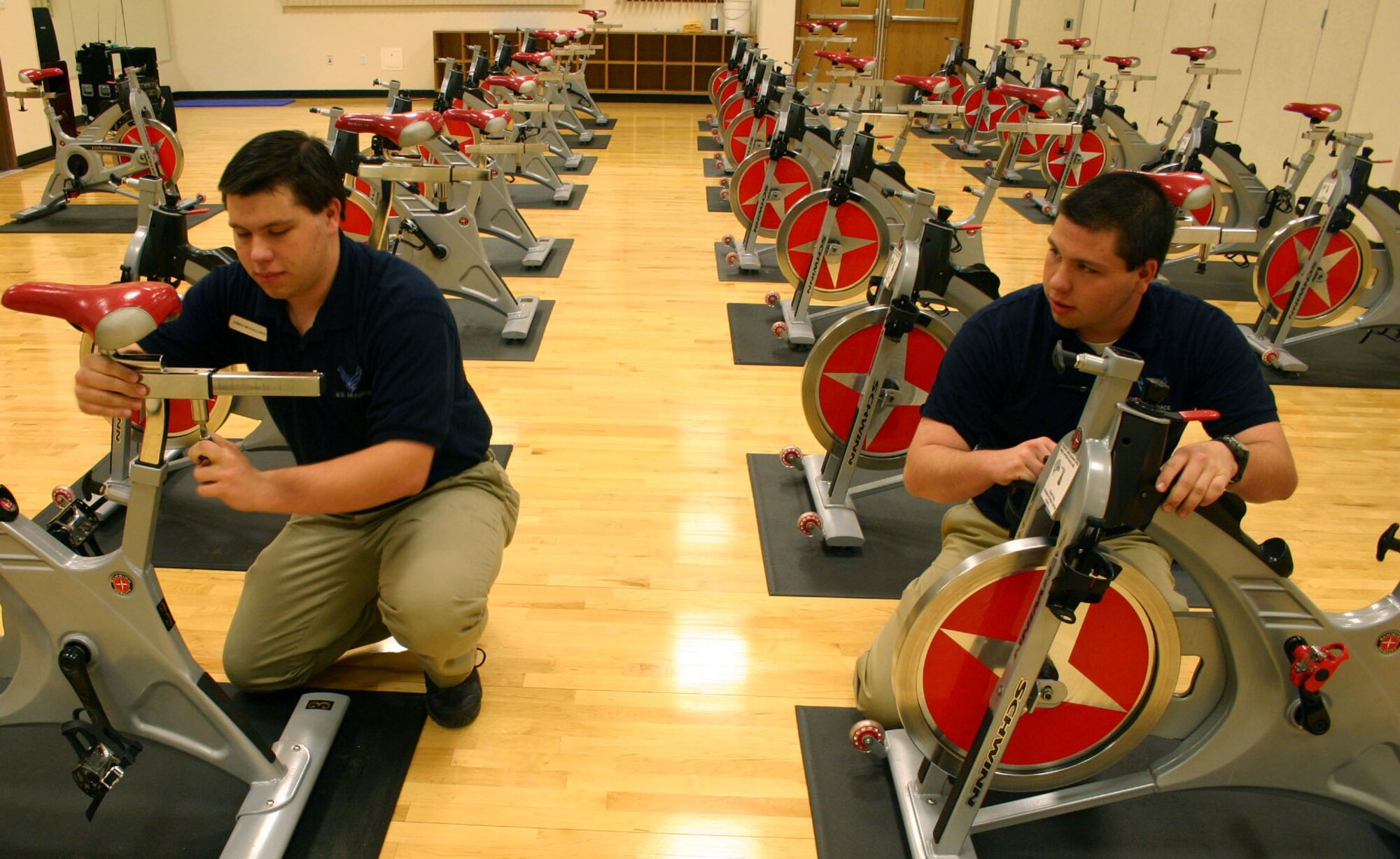 LAUGHLIN AIR FORCE BASE, Texas –Twin brothers James and Eric McGalliard, Losano Fitness Center recreational aides, maintain exercise bikes used for spin classes here April 14. The duo arrives at the fitness center most mornings hours before the sun rises to clean and maintain fitness equipment, uphold customer service and sustain reservations for the racquetball and basketball courts. “Everyday is something new here,” said James McGalliard. “Some days I get to meet new people, but there are always those die hard people that I get to see everyday.” (U.S. Air Force photo by Airman 1st Class Sara Csurilla)