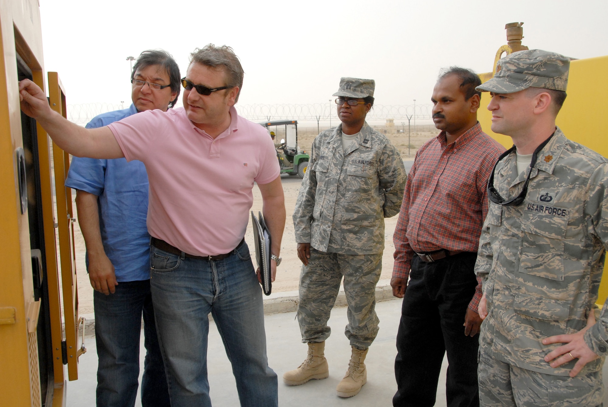 A contractor describes the functions on a generator procured by the Air Force to Maj. Tim Hawkins, Capt. Lisa Gambrel and other contractors April 12 at a Southwest Asia air base. Airmen from the 386th Expeditionary Contracting Squadron used an innovative method to procure 29 generators, called electronic reverse auctioning, to save the Air Force $395,000. Major Hawkins is the 386th ECONS commander and Captain Gambrel is a 386th ECONS contracting officer. (Air Force photo/Capt. Jason McCree) 

