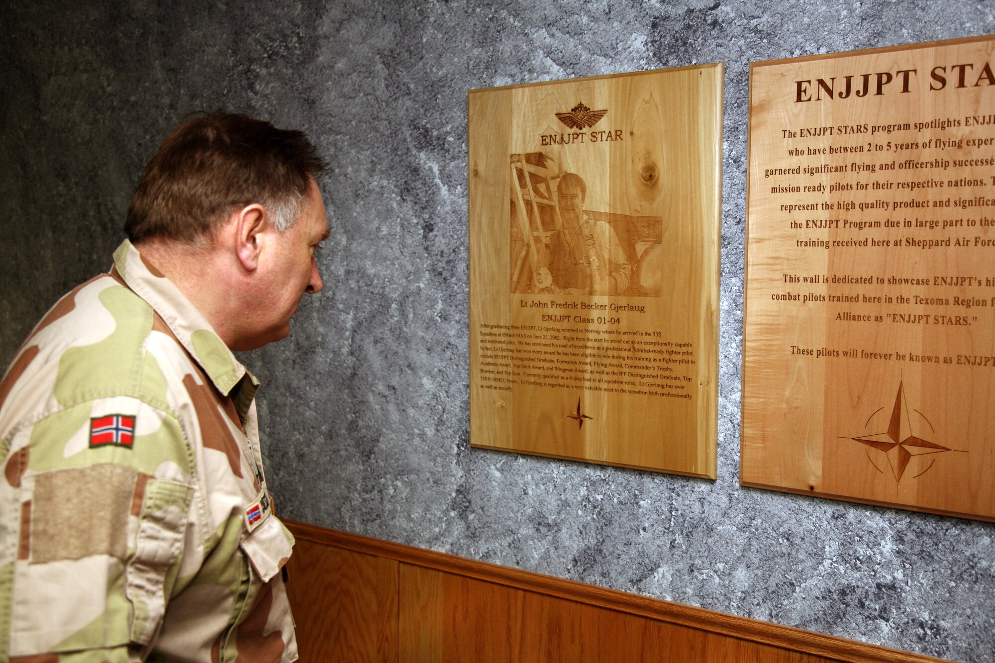 Gen. Sverre Diesen, chief of defense for Norway, reads a plaque about a Royal Norwegian Air Force pilot, Lt. John Gjerlaug, who was named a Euro-NATO Joint Jet Pilot Training Star upon completion of his training in 2002. The general paid a visit to the program April 10 that provides introductory pilot training for Norwegian military pilots. (U.S. Air Force photo/Lt. Col. Ternell Washington)