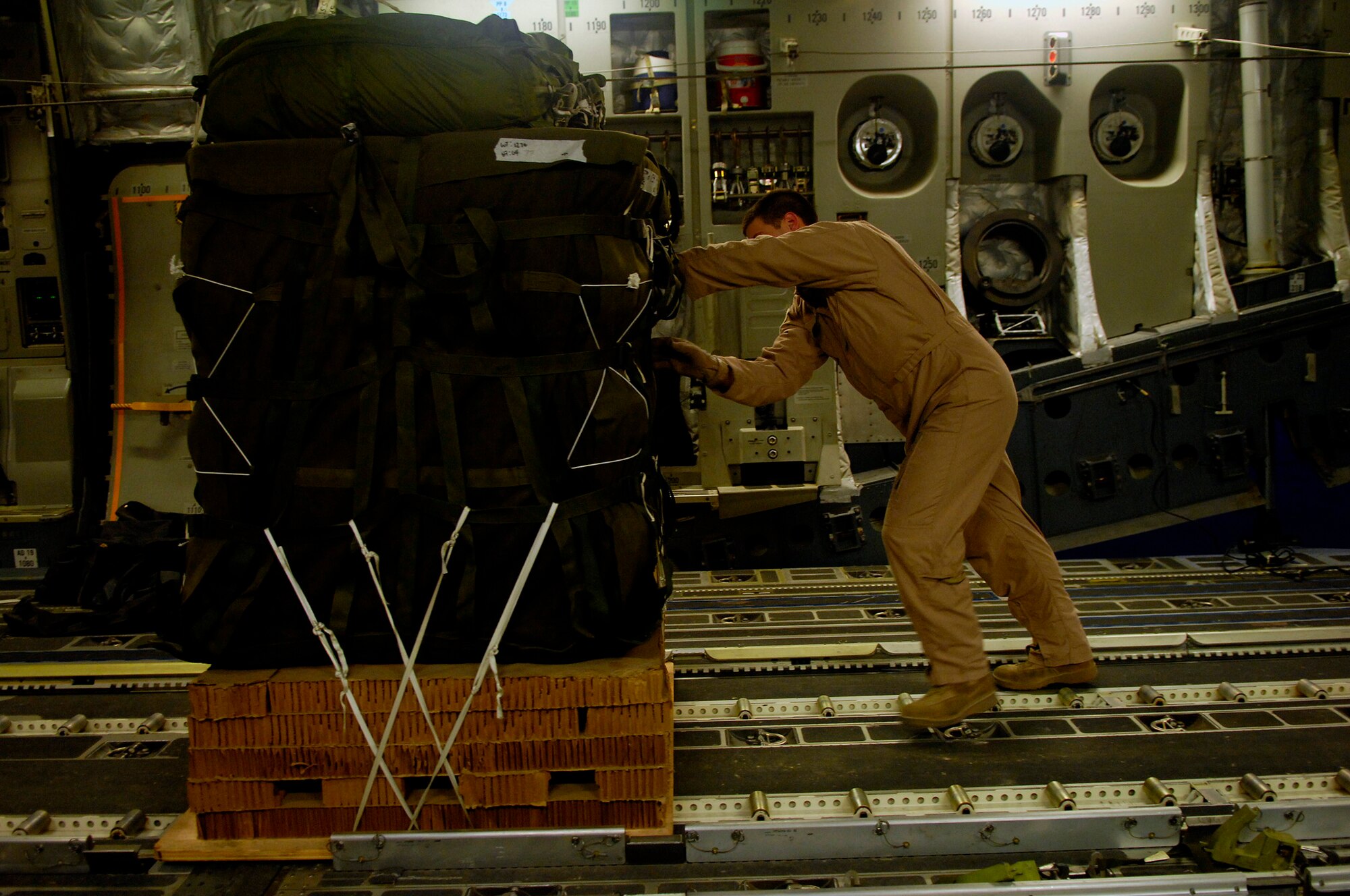 U.S. Air Force Senior Airman Spencer Stacey loads 1 of 40 bundles on a C-17 Globemaster III for a Joint Precision Airdrop Delivery System of humanitarian supplies to a drop zone in Afghanistan, Apr., 13, 2008. Stacey is from the 17th Airlift Squadron Charleston Air Force Base S.C., and is deployed to the 816th Expeditionary Airlift Squadron in Southwest Asia. (U.S. Air Force photo by Master Sgt. Andy Dunaway) (Released)
