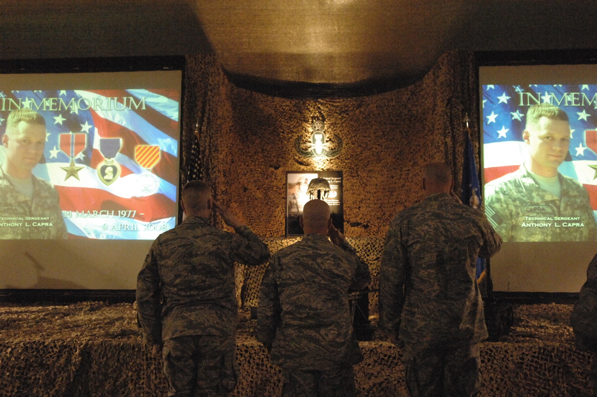 BALAD AIR BASE, Iraq -- Airmen remember their fallen comrade, Tech. Sgt. Anthony Capra, during a memorial service April 12, here.  Tech. Sgt. Anthony Capra, was a 332nd Expeditionary Civil Engineer Squadron Explosive Ordnance Disposal technician, who died in support of combat operations April 9. The memorial ceremony, which was held in Balad?s Town Hall, was attended by hundreds of Airmen and Soldiers from the EOD community and his fellow Airmen at Balad. Many of the attendees traveled to Balad from nearby forward operating locations specifically to attend the memorial for their hero and friend. Sergeant Capra was deployed from Indian Head Naval Ordnance Station, Md., Detachment 63. (U.S. Air Force photo/ Senior Airman Julianne Showalter.)