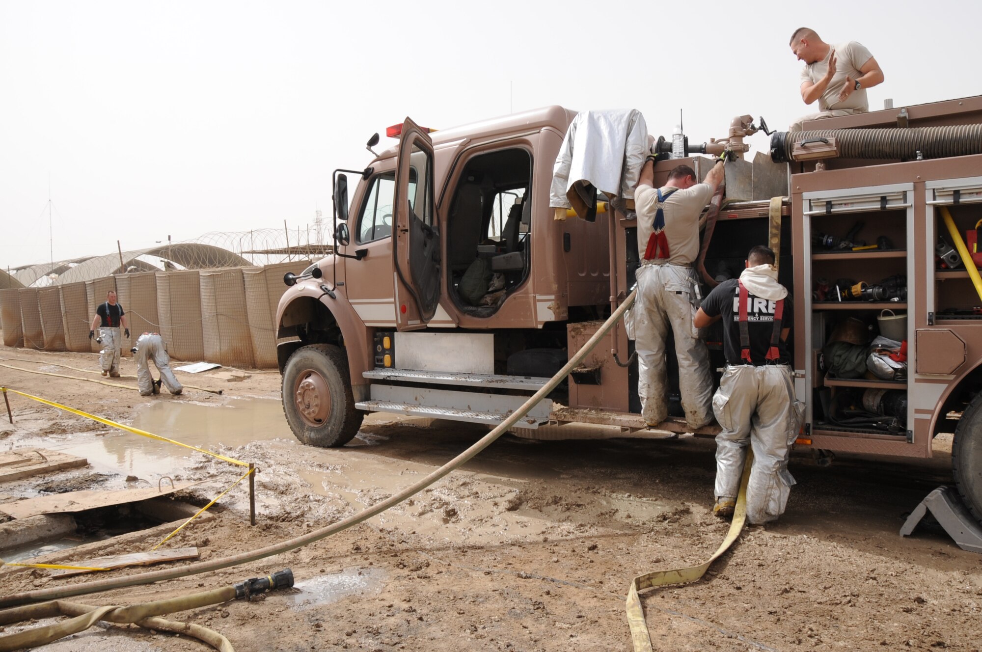 ALI BASE, Iraq -- The 407th Expeditionary Civil Engineering Squadron fire fighters pack up their gear after responding to a fire in the Romanian camp here April 11.  The Air force emergency response forces respond to all emergencies here including coalition partners, such as the Romanians, or other services, like the U.S. Army and Navy. (U. S. Air Force photo / Tech. Sgt. Sabrina Johnson)