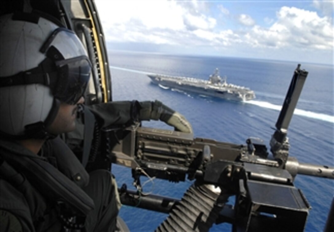 U.S. Navy Petty Officer 1st Class Jesse Hubble mans an M-240 machine gun, April 12, 2008, during a transit exercise with the Nimitz-class aircraft carrier USS Abraham Lincoln in the Philippine Straits. 