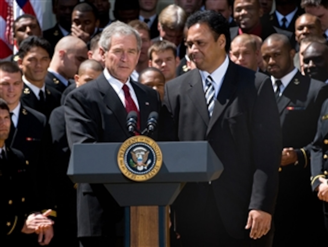 President George W. Bush congratulates U.S. Naval Academy head football coach Ken Niumatalolo after presenting the team the Commander-in-Chief trophy at a White House Rose Garden ceremony, April 14, 2008.
