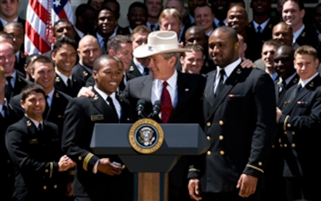 President George W. Bush dons a U.S. Naval Academy cowboy hat presented to him by midshipmen team captains Reggie Campbell, left, and Irv Spencer after presentation of the Commander-in-Chief trophy to the football team in a White House Rose Garden ceremony, April 14, 2008. 