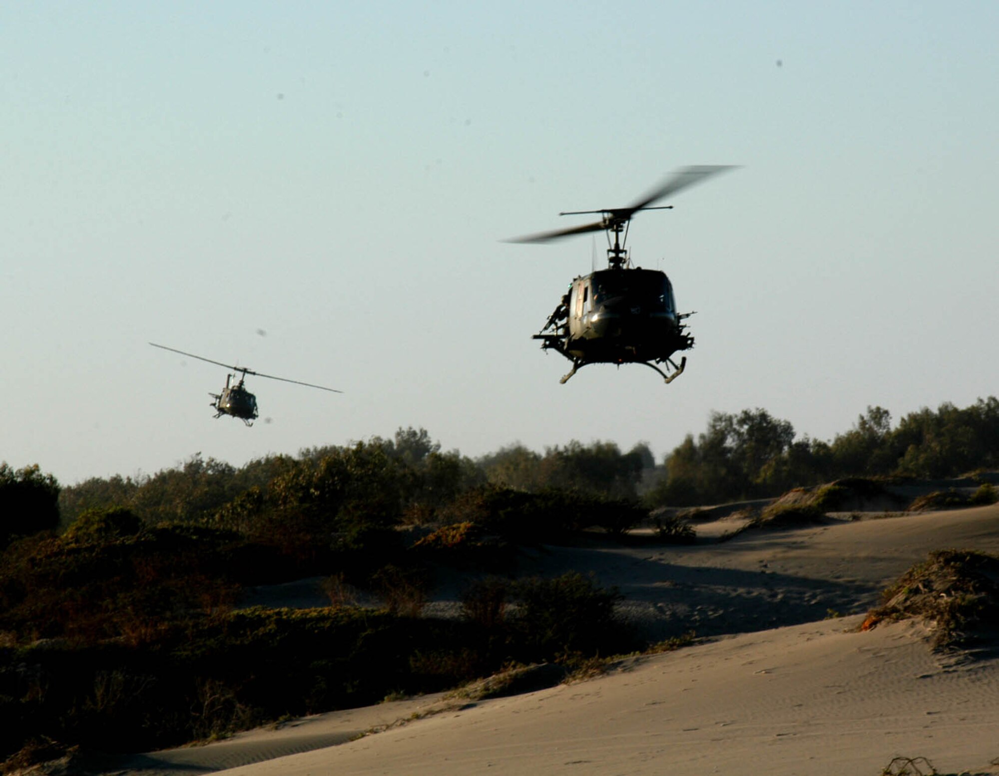 Two UH-1 Huey Helicopters swoop in to assist U.S. and Chilean Air Force pararescue personnel involved in a mass casualty evacuation exercise during NEWEN, a three-day combined military exercise, April 8-10. The NEWEN exercise focused on refueling operations, search and rescue tactics and dissimilar aircraft maneuvers with members of the Chilean Air Force.(photo by U.S. Embassy- Chile)