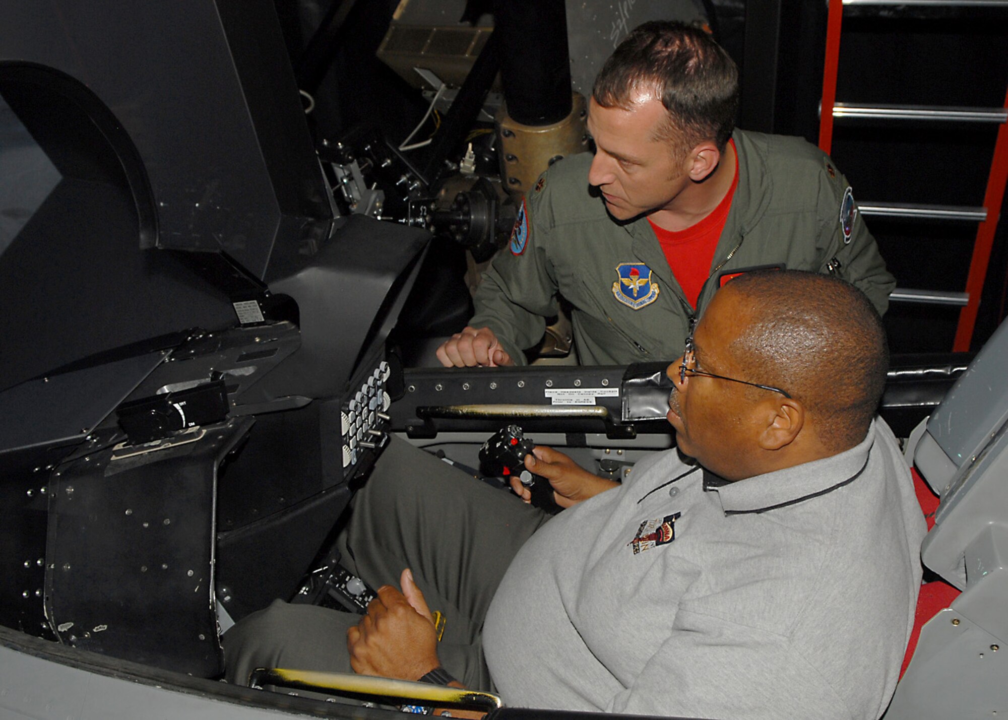 Major Jeffrey "Psycho' Simons, Assistant Director of Operations, 56th Training Squadron, assists Larry King, a Paradise Valley Judge and Honorary Commander with the 756th Aircraft Maintenance Squadron, in flying the F-16 simulator.