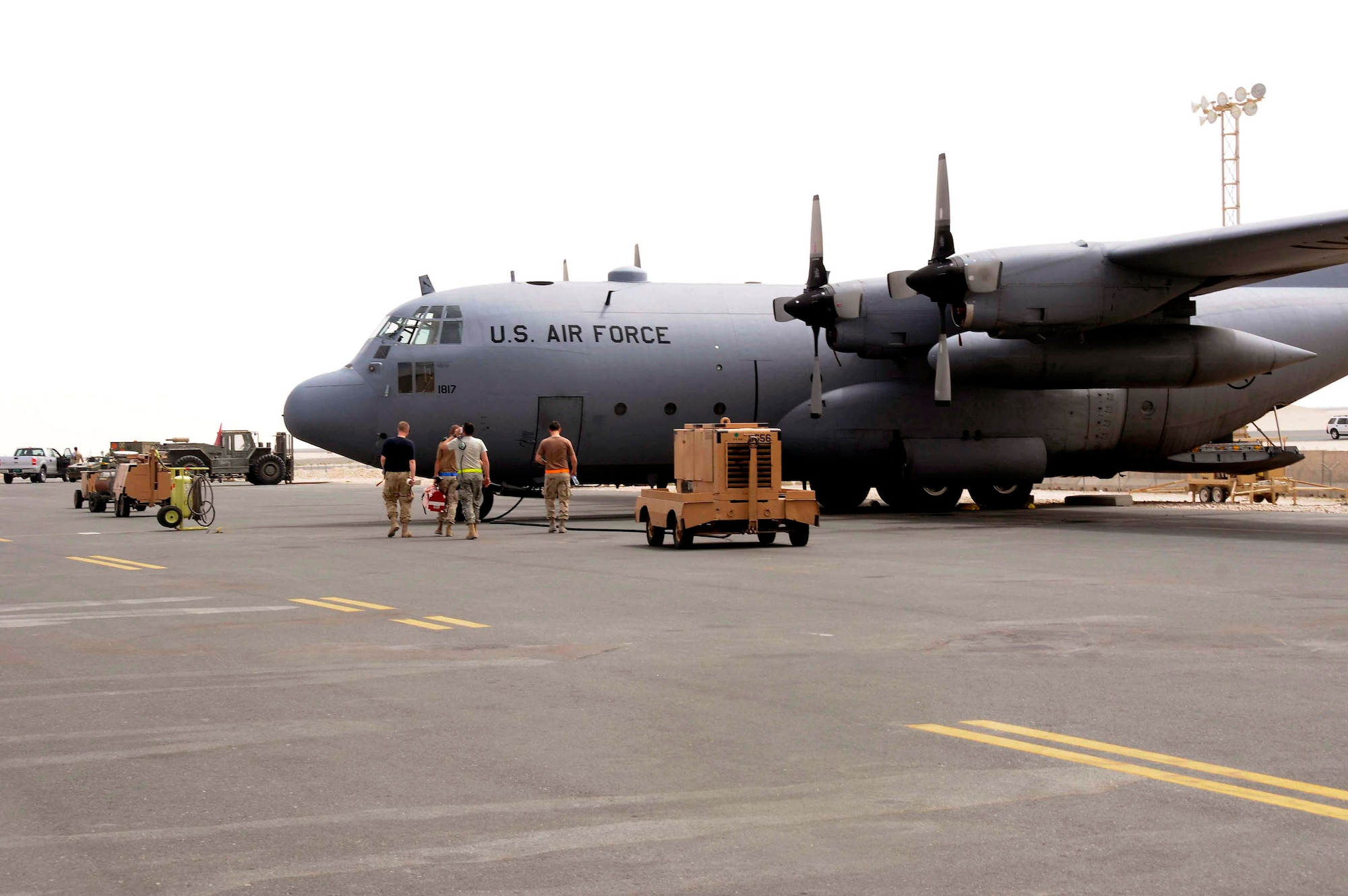 Members of the 746th Expeditionary Aircraft Maintenance Unit at an air base in Southwest Asia prepare to do maintenance on a C-130 Hercules.  The newly acquired aircraft, known as "Patches," is a Vietnam-era C-130E, tail number 62-1817, with quite a history.  (U.S. Air Force photo/Senior Airman Domonique Simmons.) 
