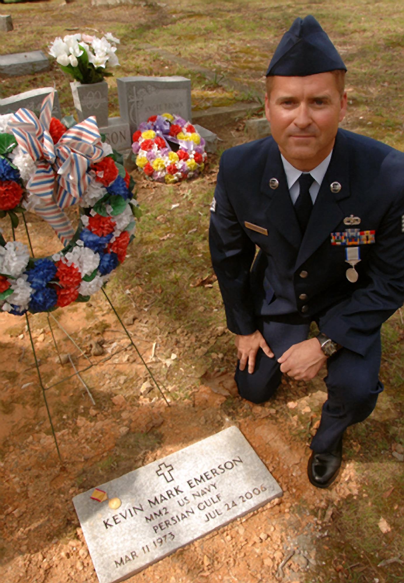 Staff Sgt. John M. Rosenberry Sr. poses alongside the gravesite of his friend Kevin Mark Emerson in Jetersville, Va., April 11. Sergeant Rosenberry was awarded the Coast Guard Silver Lifesaving medal, and Emerson was posthumously awarded the Gold Lifesaving Medal for the heroic rescue of two young boys caught in a riptide while vacationing in the Outer Banks of North Carolina in July 2006. Mr. Emerson died as a result of his heroic actions. (U.S. Coast Guard photo/Petty Officer 2nd Class Christopher Evanson)