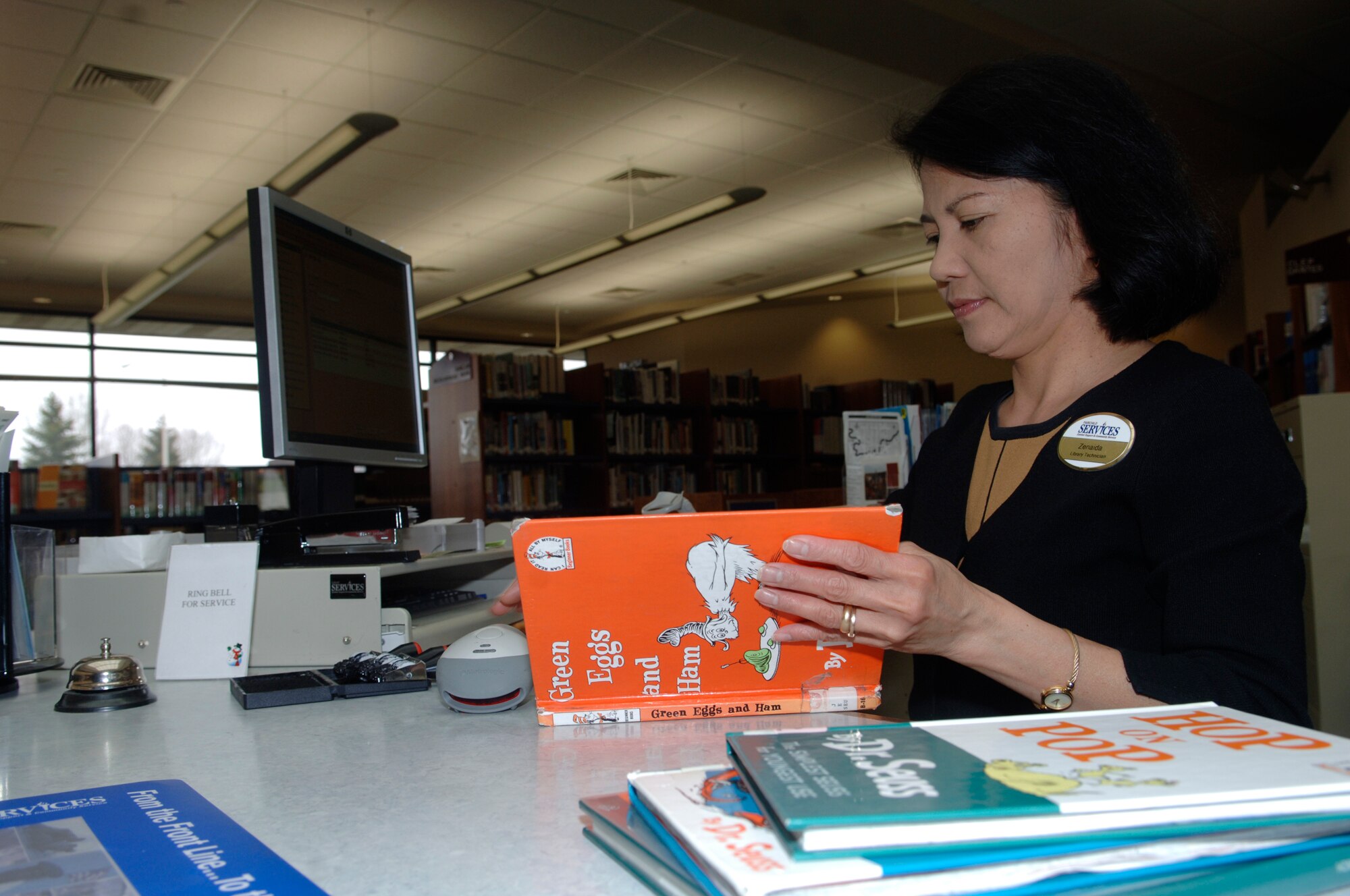 FAIRCHILD AIR FORCE BASE, Wash. – Zeny Escusa, library technician, checks in books at the base library on April 14. (U.S. Air Force photo/Senior Airman Chad Watkins)