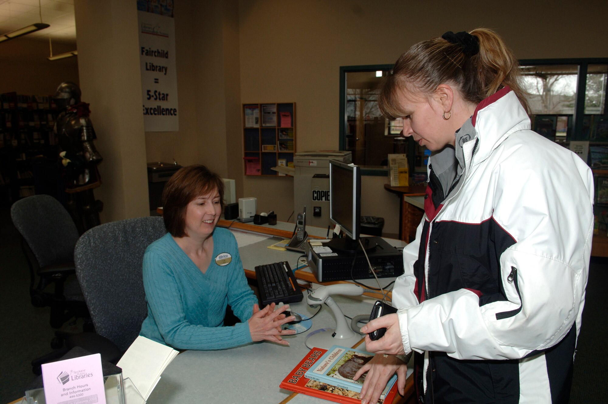FAIRCHILD AIR FORCE BASE, Wash. – Lisa Love, acting library director, checks out a book to Wenda Houston, wife of Senior Master Sgt. Reco Houston, 92nd Civil Engineering Squadron, at the base library on April 14. (U.S. Air Force photo/Senior Airman Chad Watkins)