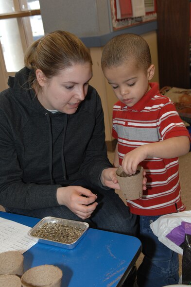MINOT AIR FORCE BASE, N.D.-April Wolverton, a Preschool-C class teacher at the Child Development Center here, helps Jeremiah Palumbo plant a Marigold seed April 11. Jeremiah is the son of Staff Sgt. Sarah Cook, 91st Security Support Squadron. Planting flowers is one of the many activities happening at the CDC during the month of April to mark Month of the Military Child. (U.S. Air Force photo by Senior Airman Cassandra Jones)