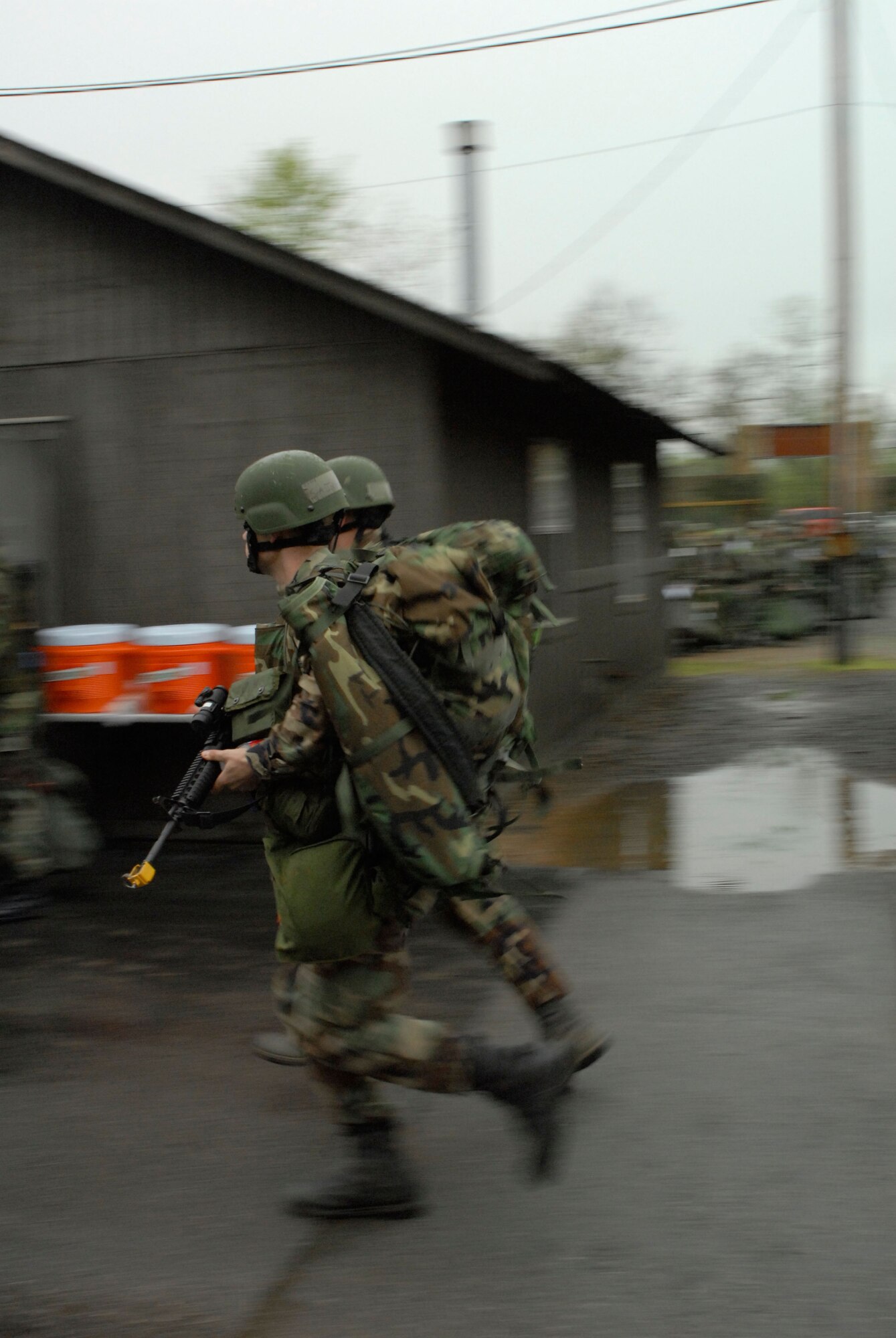 Two 189th Security Forces Squadron Airmen run toward their defensive fighting position to secure the exercise area. (Photo by Senior Airman Julian Johnson)