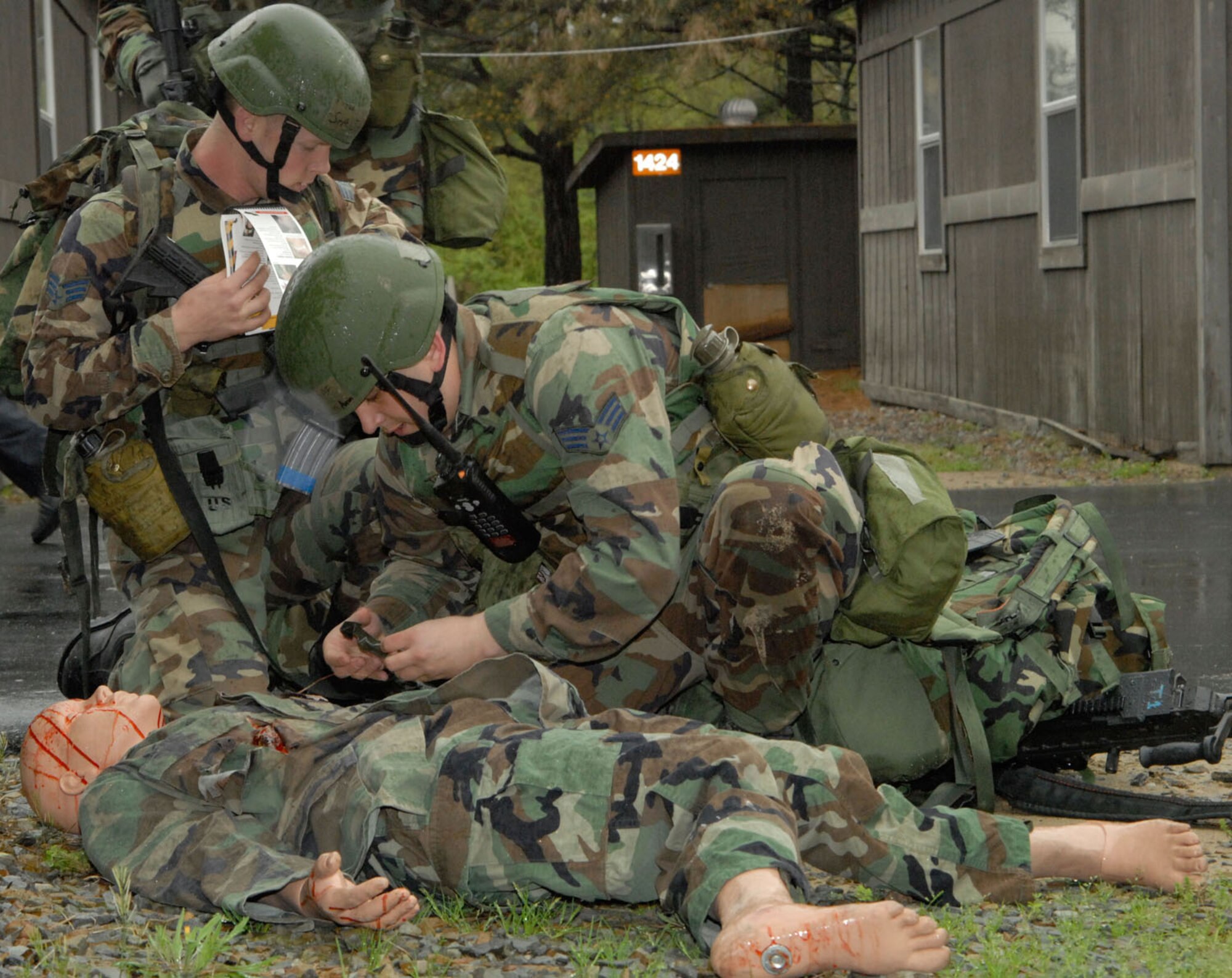 Senior Airman Aaron Anderson administers emergency care to a casualty while Senior Airman Christopher B. Johnson checks his Airman’s Manual. Both are members of the 189th Security Forces Squadron. (Photo by Senior Airman Julian Johnson)