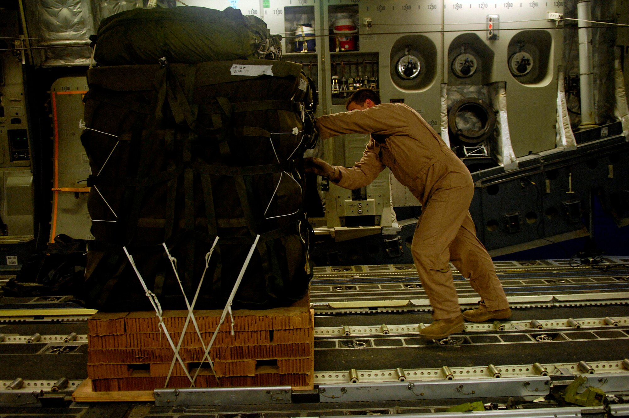Senior Airman Spencer Stacey loads one of 40 bundles on a C-17 Globemaster III for a Joint Precision Airdrop Delivery System of humanitarian supplies to a drop zone April 13 in Afghanistan. Airman Stacey is from the 17th Airlift Squadron from Charleston Air Force Base, S.C., and is deployed to the 816th Expeditionary Airlift Squadron in Southwest Asia. (U.S. Air Force photo/Master Sgt. Andy Dunaway) 