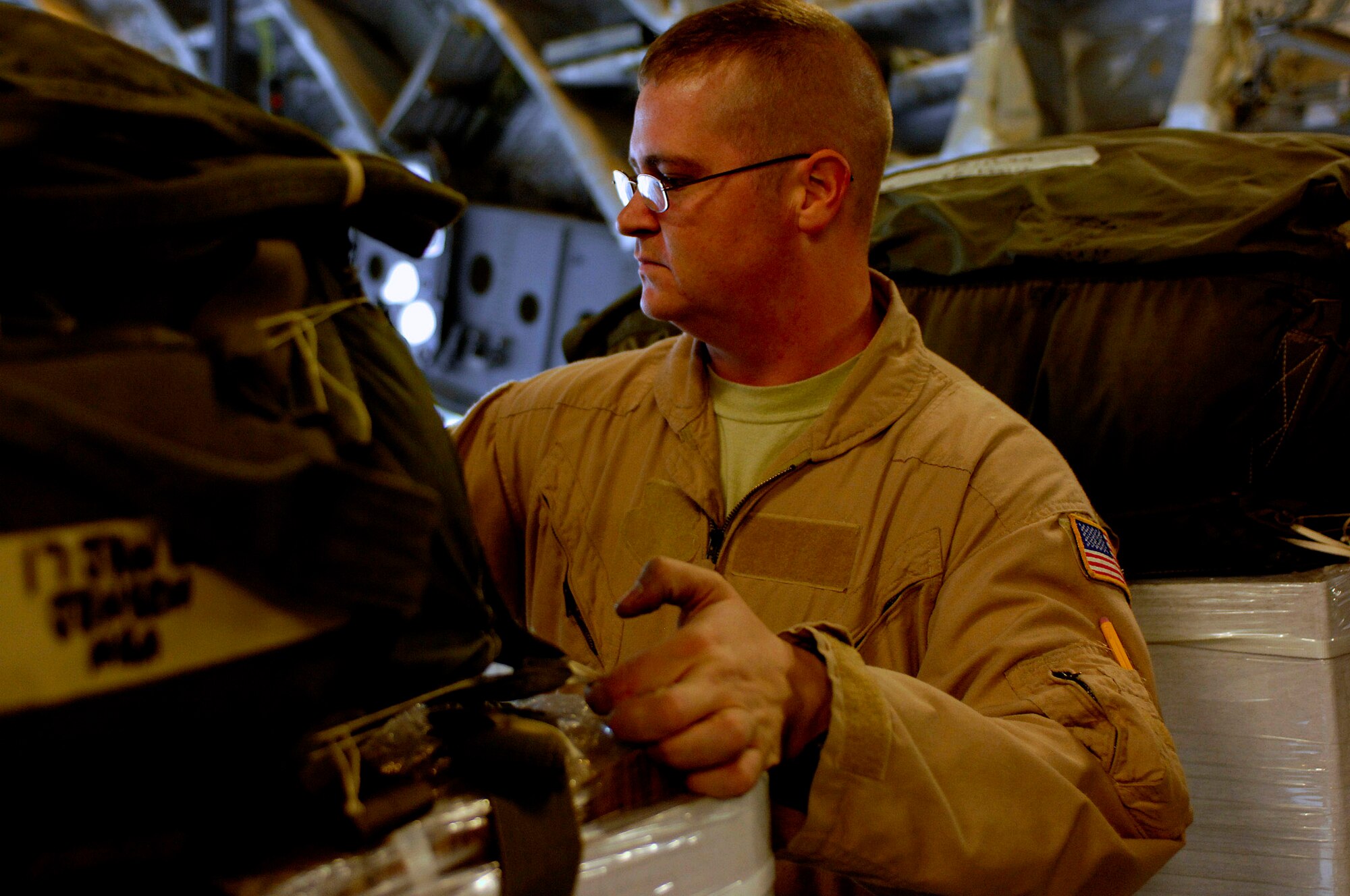 Tech. Sgt. Michael Gillan inspects the bundles for the container deliver system on a C-17 Globemaster III for a Joint Precision Airdrop Delivery System of 40 bundles of humanitarian supplies to a drop zone April 13 in Afghanistan. Sergeant Gillan is a loadmaster from the 17th Airlift Squadron from Charleston Air Force Base S.C., and is deployed to the 816th Expeditionary Airlift Squadron in Southwest Asia. (U.S. Air Force photo/Master Sgt. Andy Dunaway)