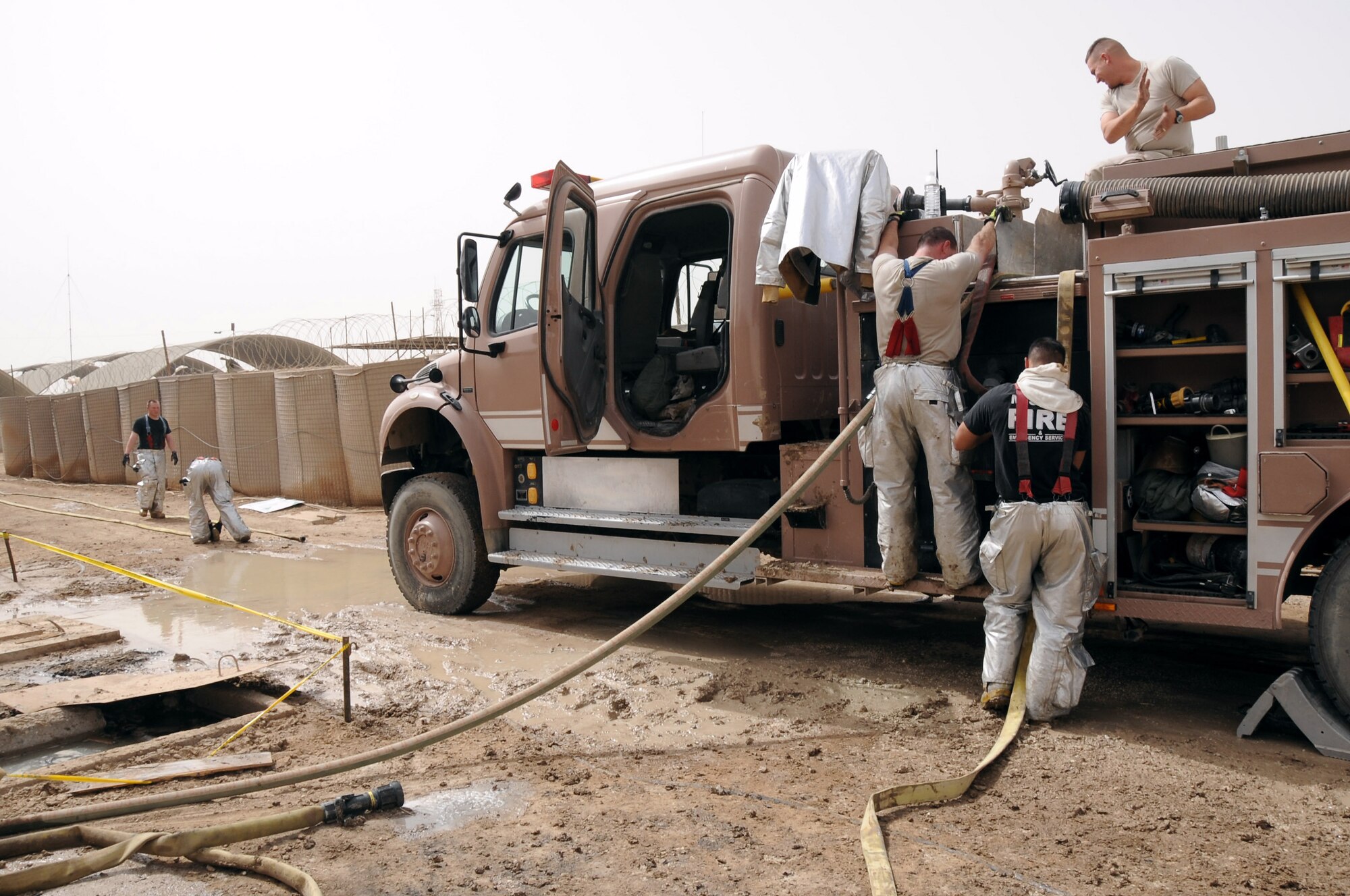 The 407th Expeditionary Civil Engineering Squadron firefighters pack up their gear after responding to a fire in the Romanian camp April 11 at Ali Base, Iraq. The Air Force emergency response forces respond to all emergencies here including coalition partners. (U.S. Air Force photo/Tech. Sgt. Sabrina Johnson) 
