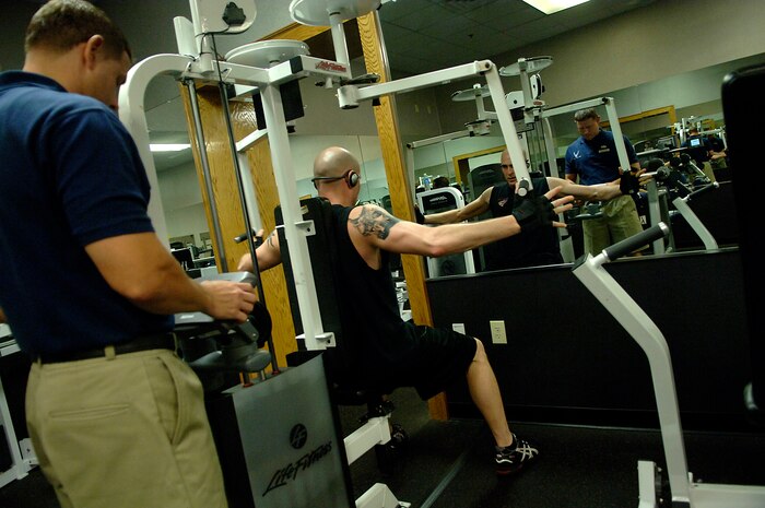 Tech. Sgt. Shawn McKeen trains Tech. Sgt. Andrew Leighty during a workout at the 437th Force Support Squadron Fitness and Sports Center on Charleston AFB Tuesday. The 437th Mission Support and Services Squadrons merged April 10 to make one team as part of an Air Force initiative. Sergeant McKeen is the NCO in charge of the 437 FSS' Fitness and Sports Center and Sergeant Leighty is with the 437th Maintenance Operations Squadron. (U.S. Air Force photo/Senior Airman Nicholas Pilch) 