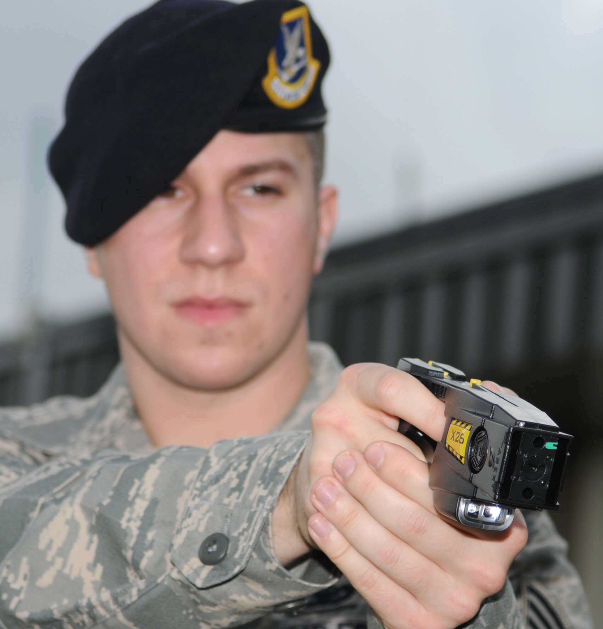 Sergeant Nadler aims a taser at a target.  (U.S. Air Force photo by Kemberly Groue)