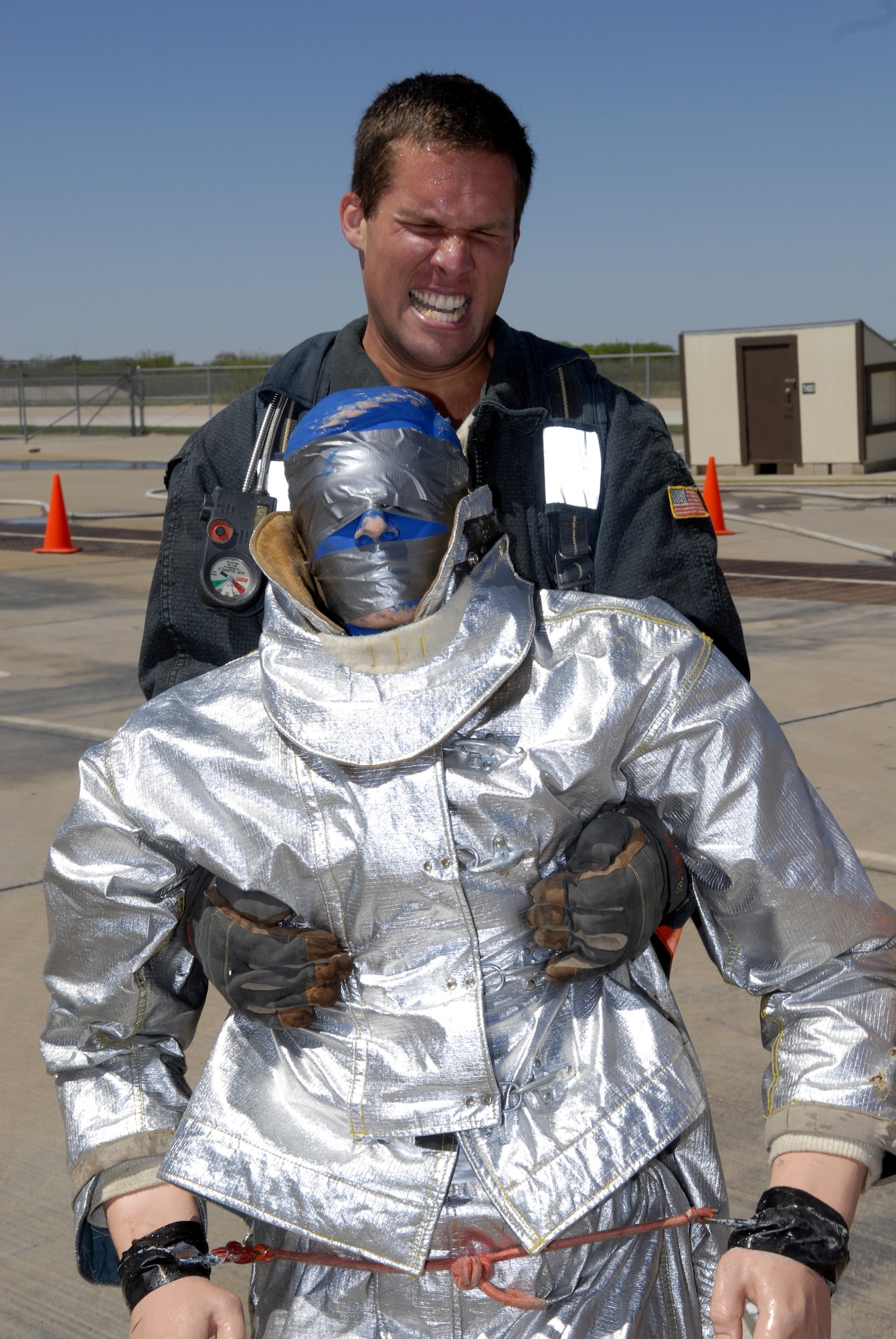Andy tries to move a 175-pound dummy through the last 100 feet of the obstacle course. He collapsed approximately 50 feet short of the finish, due to complete exhaustion. (U.S. Air Force photo by Senior Airman Kamaile Chan)