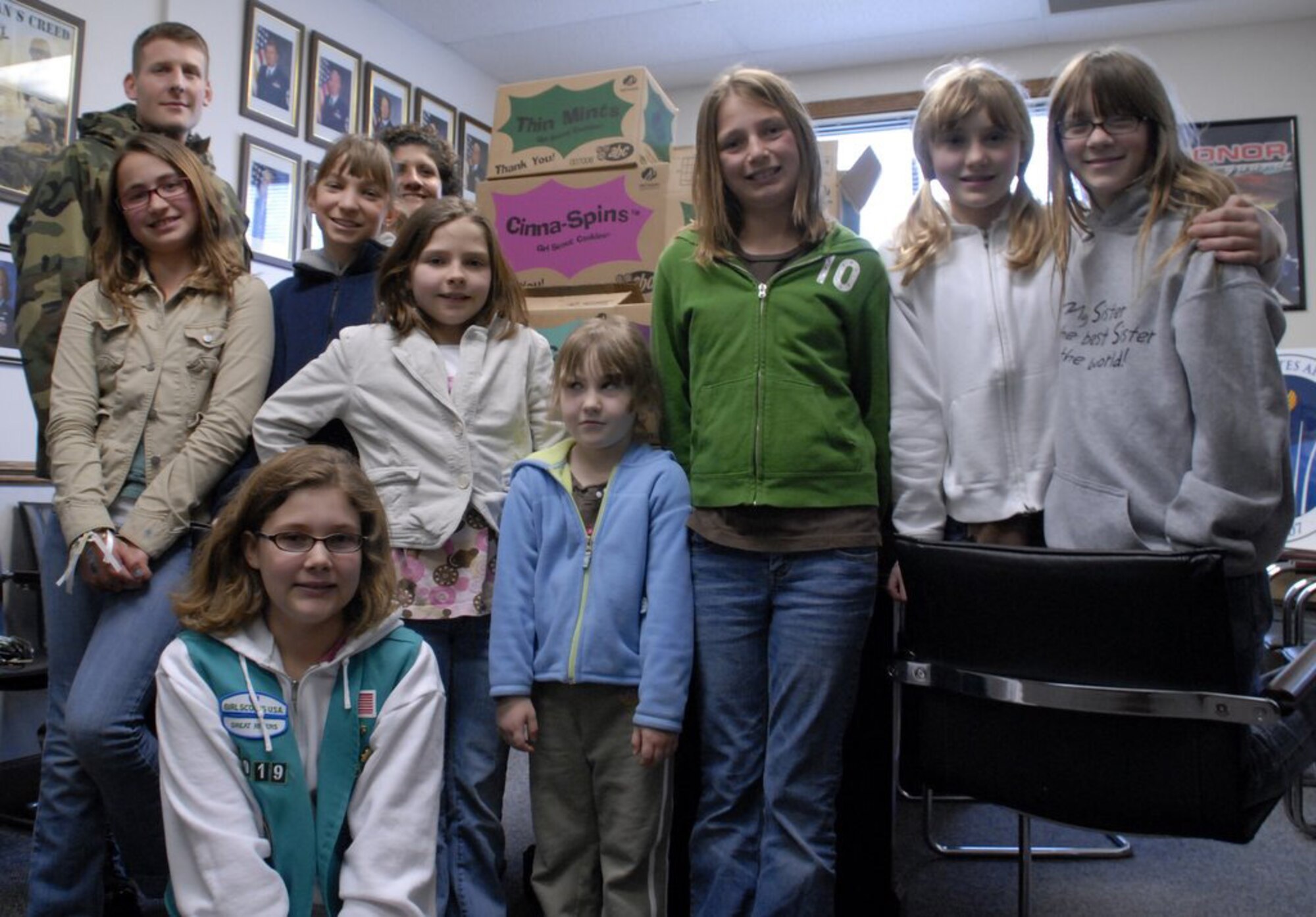 WRIGHT-PATTERSON AFB, Ohio - Tech. Sgt. David Hayes, 445th Logistics Readiness Squadron, and Senior Master Sgt. Lisa Rodriguez, 445th Maintenance Squadron First Sergeant, accept cookies from members of Girl Scout Troop 5919, Springboro, Ohio. The scouts donated almost 200 boxes of cookies, 18 cases in all, that will be sent to military members down range. This is at least the fourth time Troop 5919 has brought cookies to the 445th. The troop was treated to a tour of a C-5 Galaxy after delivering the cookies to the wing. (U.S. Air Force photo/Tech. Sgt. Charlie Miller)
