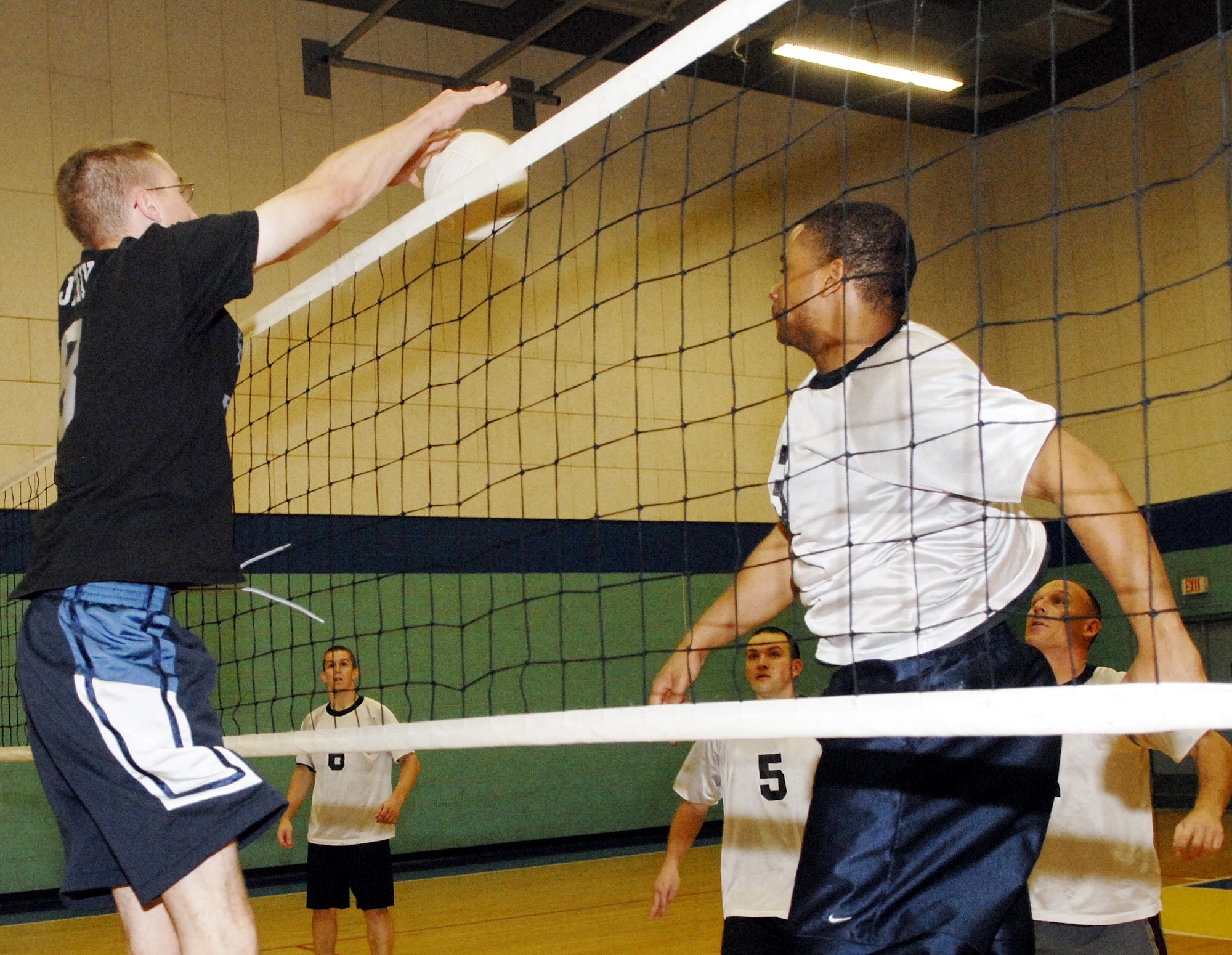 Airman 1st Class Scott Janik (left) from the 315th Bravo Rattlers team blocks a spike from 17 MSG team member Airman 1st Class Leverne Jackson during the championship game.  (U.S. Air Force photo by Senior Airman Kamaile Chan)
