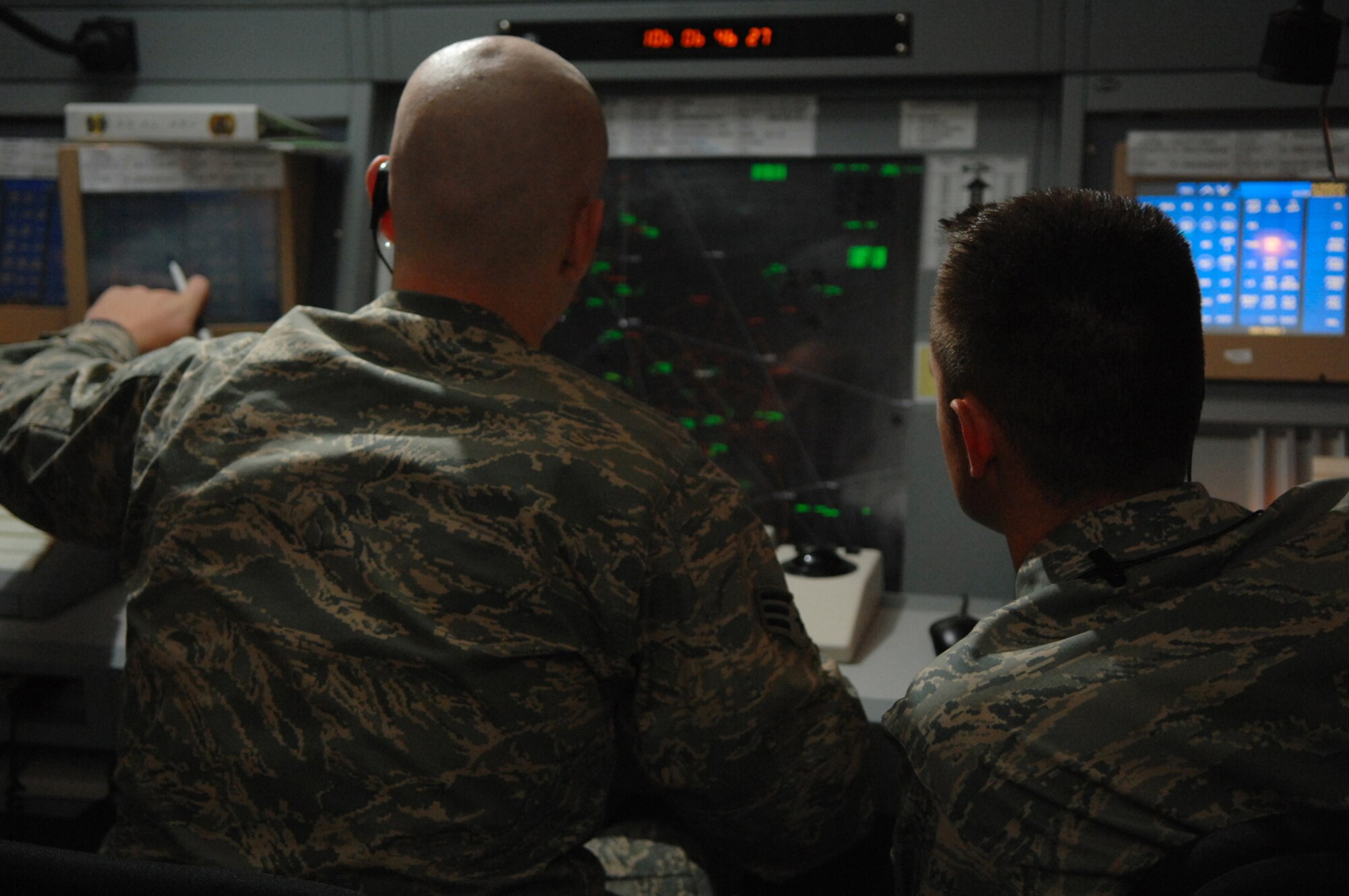 Air traffic controllers from the 332nd Expeditionary Operations Squadron, Senior Airman Aaron Portmann and Tech. Sgt. Michael Henderson, help direct air traffic in the Iraqi theater of operations here, April 15. Airman Portmann and Sergeant Henderson work for the 332 EOSS Combined Enroute Radar Approach control office, which is known as CERAP. This office was recently relocated to a new, state-of-the-art facility and CERAP controllers now work side-by-side with the controllers of the 727th Expeditionary Air Control Squadron, which is known as Kingpin. The relocation helps the two groups of controllers communicate with each other and provide a timelier ?picture? of air traffic in the theater to the Combined Air Operations Center. Airman Portmann is deployed from Dover Air Force Base, Del.; Sergeant Henderson is deployed from Altus AFB, Okla. (U.S. Air Force photo/ Senior Airman Julianne Showalter)