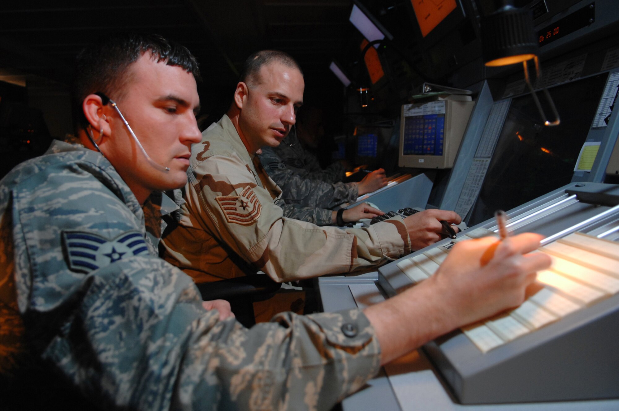Air traffic controllers from the 332nd Expeditionary Operations Squadron, from left, Staff Sgt. Ryan Tripp and Tech. Sgt. John Neff, help direct air traffic in the Iraqi theater of operations here, April 15. Sergeants Tripp and Neff work for the 332 EOSS Combined Enroute Radar Approach control office, which is known as CERAP. This office was recently relocated to a new, state-of-the-art facility and now CERAP controllers work side-by-side with the controllers of the 727th Expeditionary Air Control Squadron, which is known as Kingpin. The relocation helps the two groups of controllers communicate with each other and allows them to provide a timelier ?picture? of air traffic in the theater to the Combined Air Operations Center. Sergeant Tripp is deployed from Whiteman Air Force Base, Mo.; Sergeant Neff is deployed from Aviano Air Base, Italy. (U.S. Air Force photo/ Senior Airman Julianne Showalter)
