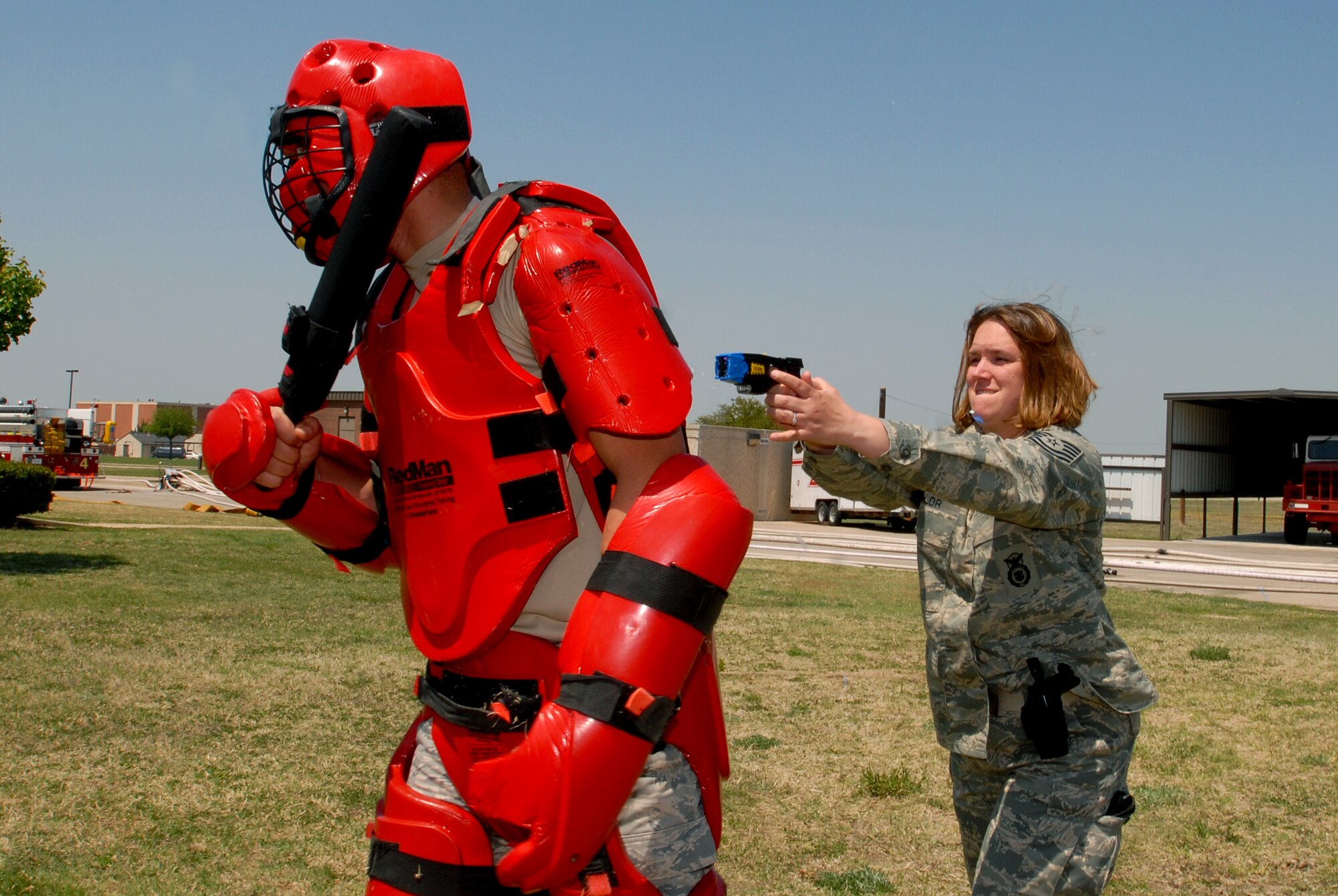 Technical Sergeant Rachel Taylor prepares to deploy her Taser on a red-suited Airman 1st Class Charles Bird during Taser training Tuesday. (U.S. Air Force photos by Tech. Sgt. Gina O’Bryan)