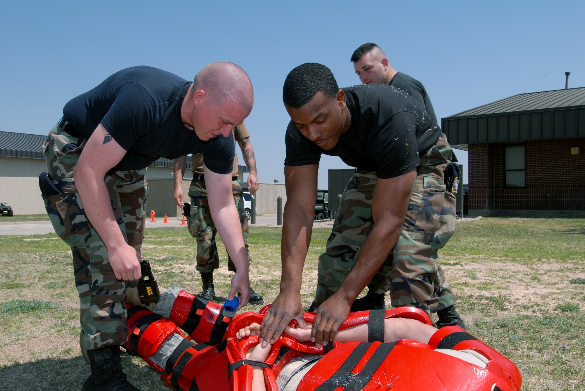 Members of the 17th Security Forces Squadron apply simulated handcuffs to Airman Bird before removing the Taser electrodes. (U.S. Air Force photos by Tech. Sgt. Gina O’Bryan)