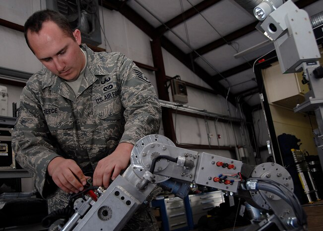 Staff Sgt. Matthew Reece tightens down a tool on a robot during a training exercise on Charleston AFB Sunday. Explosive ordnance disposal Airmen train so they can be proficient during disposal of explosive devices.   Sergeant Reece is an EOD technician for the 315th Airlift Wing.  (U.S. Air Force photo/Airman 1st Class Katie Gieratz)