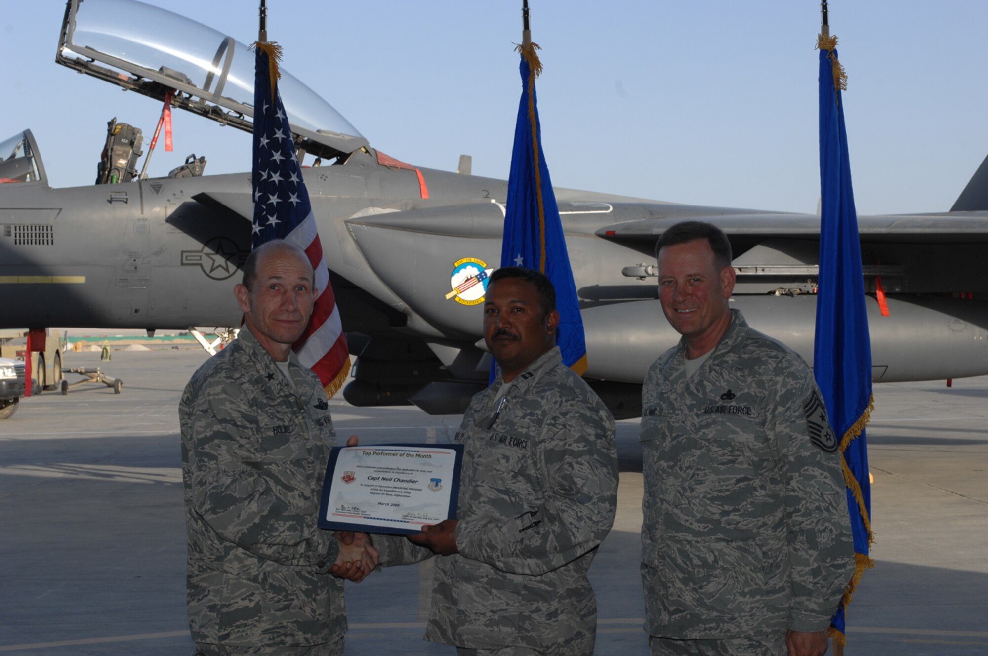 SEYMOUR JOHNSON AIR FORCE BASE, N.C. -- Capt. Neil Chandler (center) receives the Company Grade Officer of the Quarter award from Brig. Gen. Mike Holmes (left), former commander of the 4th Fighter Wing and current commander of the 455th Air Expeditionary Wing in Bagram, Afghanistan. Also present is 455th AEW Command Chief Ray Clark. Capt. Chandler is an officer with the 916th Logistics Readiness Squadron and deployed to Afghanistan earlier this year.