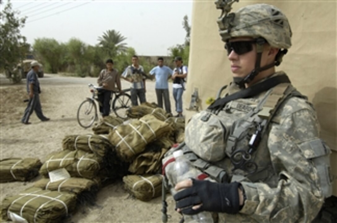 U.S. Army Spc. Dustin Deards stands guard during a humanitarian aid mission in Mohammed al-Hindi village, Wasit Province, Iraq, on April 8, 2008.  Deards and his fellow soldiers of 1st Platoon, Alpha Company, 1st Battalion, 15th Infantry Regiment, 3rd Brigade Combat Team, 3rd Infantry Division, are delivering bundles of clothing and blankets to Iraqis in Mohammed al-Hindi village.  