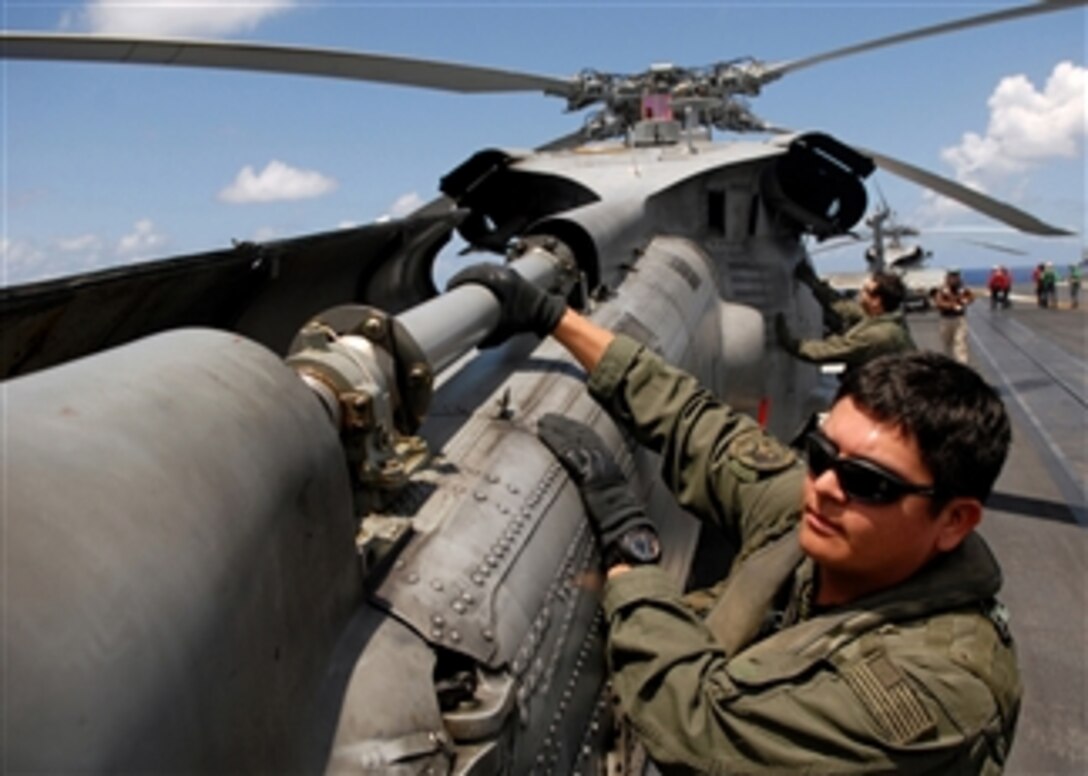 Petty Officer 2nd Class Vincent Rodriguez inspects the tail rotor drive shaft as he performs a preflight check on an HH-60H Seahawk helicopter on the aircraft carrier USS Abraham Lincoln (CVN 72) as the ship operates in the Pacific Ocean on April 11, 2008.  Rodriquez is a Navy Aviation Warfare Systems Operator assigned to Helicopter Anti-Submarine Squadron 2.  