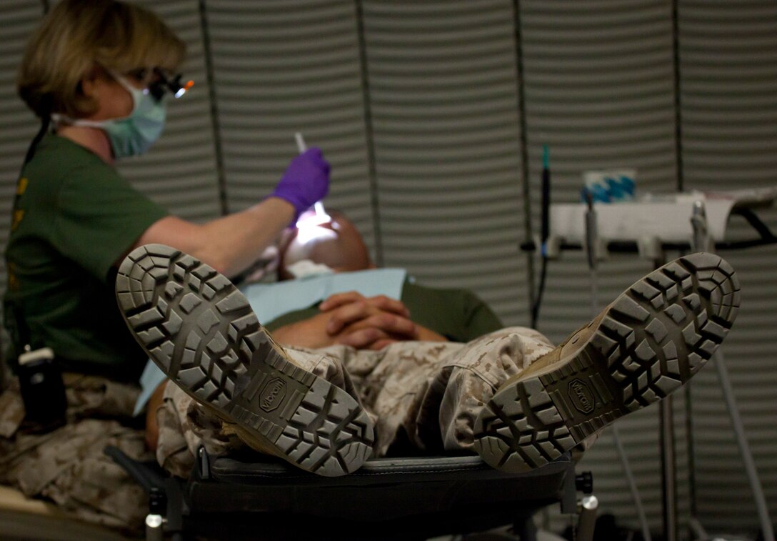 Lt. Cmdr. Margaret Huffman, Aliso Viejo, Calif., with 4th Dental Company, performs a field oral cleaning at Exercise Javelin Thrust 2012. Javelin Thrust is an annual large-scale exercise here which allows active and reserve Marines and sailors from 38 different states to train together as a seamless Marine Air Ground Task Force.