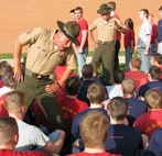Drill Instructor Sgt. Edgar Ramirez (left) teaches the poolees of Recruiting Substations Kalamazoo and Battle Creek that you "don't ever touch your face," while Drill Instructor Staff Sgt. Damian Rodriguez teaches the poolees how to get in formation during Family night April 16. Three drill instructors talked to the parents and poolees about the transformation their sons or daughters would go through during their 13 weeks in recruit