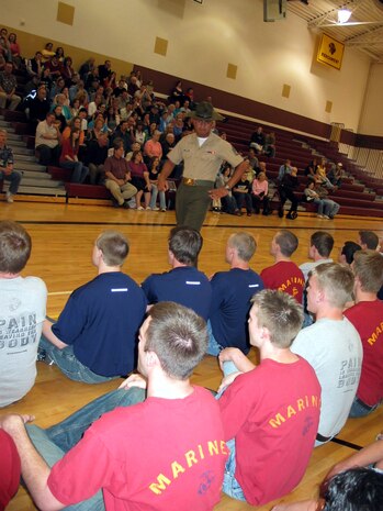 Drill Instructor Staff Sgt. Damian Rodriguez teaches the poolees how to get in formation during a family night event April 16 for Recruiting Substations Kalamazoo and Battle Creek. Three drill instructors talked to the parents and poolees about the transformation their sons or daughters would go through during their 13 weeks in recruit training. Rodriguez is assigned to 1st Recruit Training Battalion, Delta Company, Marine Corps Recruit Depot San Diego.