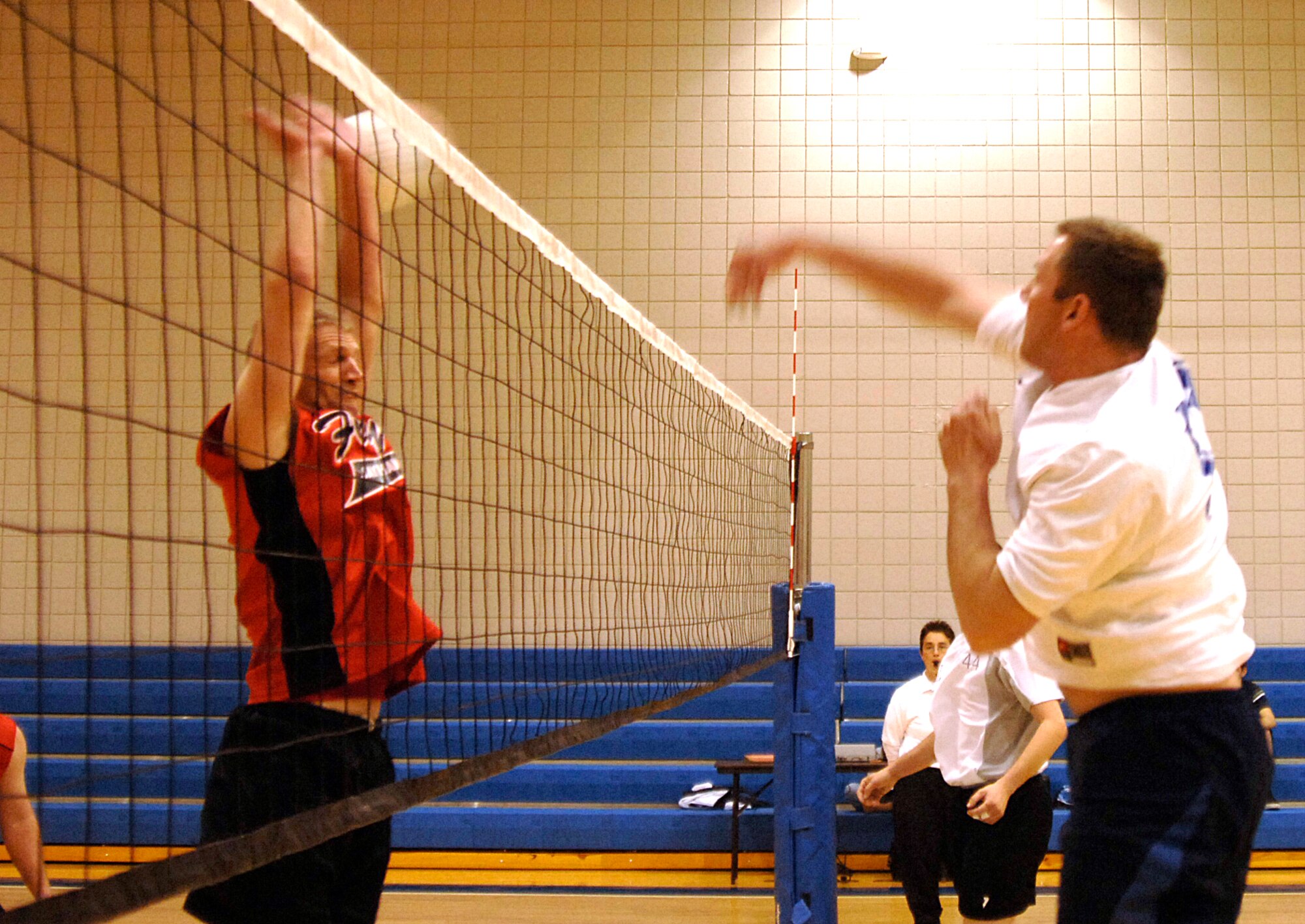 MCCONNELL AIR FORCE BASE, Kan. -- Staff Sgt. Michael Fridley, 22nd Logistics Readiness Squadron, spikes the ball at Tech. Sgt. Adam Fortner, 184th Intelligence Wing, at the fitness center here, April 10.  This LRS team won 20-25, 25-21, 15-11, bringing their record to four wins and zero losses this season. (Photo by Staff Sgt. Ronald Lafosse.)