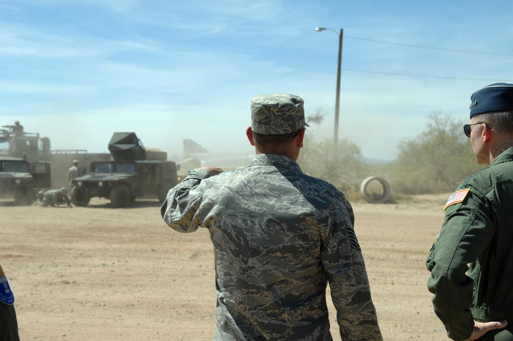 Tech. Sgt. Brad Tomazic, 355th Logistics Readiness Squadron, explains the scenario as Gen. John Corley, Air Combat Command commander, watches the 355th LRS and 355th Security Forces Squadron perform a mock attack on a convoy during General Corley's visit to Davis-Monthan April 15. (U.S. Air Force photo by Airman 1st Class Noah R. Johnson)