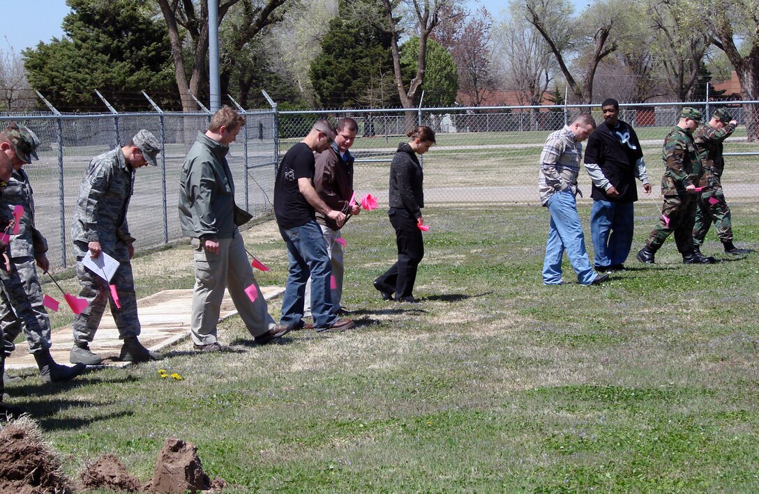 People from bioenvironmental, the Air Force Office of Special Investigations, security forces and the fire department at Vance Air Force Base, Okla., walk a grid and mark evidence during an exercise April 15 on how to preserve and process a chemical or weapon of mass destruction scene that may be a result of criminal activity. The first responders received the training on how to process a hazardous materials incident from an AFOSI crime scene investigator. (Air Force photo/Capt. Tony Wickman)