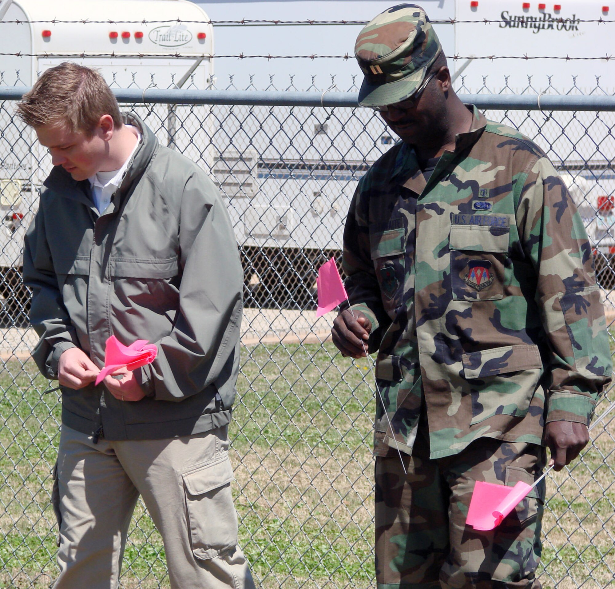 Special Agent Skip Wheeler, Air Force Office of Special Investigations Detachment 438, and Capt. Timothy Brathwaite, 71st Medical Group bioenvironmental engineering, walk a grid and mark evidence during an exercise April 15 at Vance Air Force Base, Okla., on how to preserve and process a chemical or weapon-of-mass-destruction scene that may be a result of criminal activity. (U.S. Air Force photo/Capt. Tony Wickman)