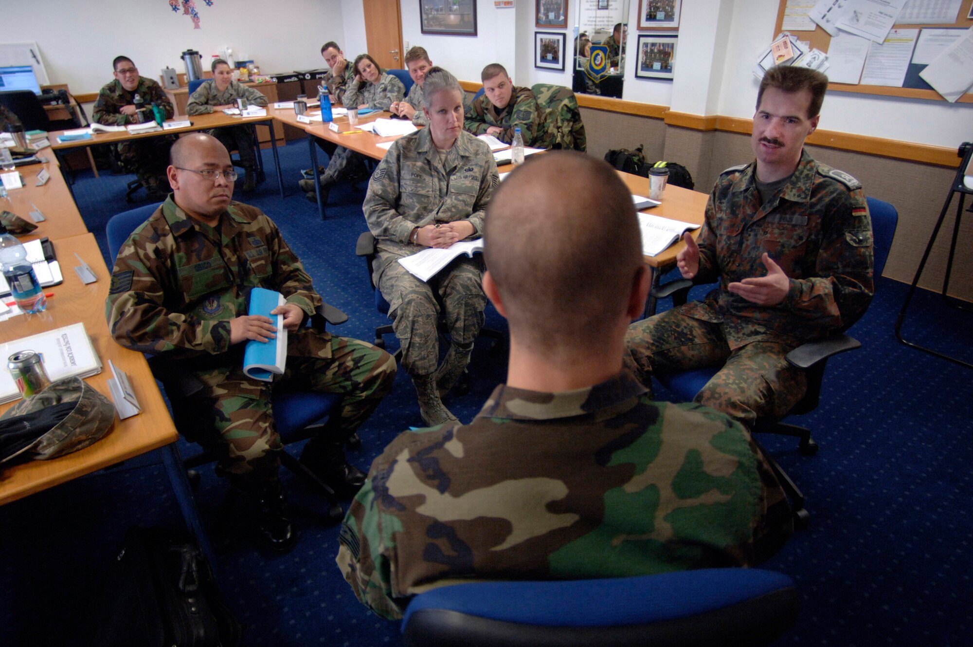 German air force Master Sgt. Holger Fels (right) takes part in a scenario that teaches supervisors how to involve subordinates in the process of problem sovling during his fifth week of study March 26 at the Kisling NCO Academy at Kapaun Air Station, Germany. Sergeant Fels voluntarily enrolled in the six-week course to prepare for his next assignment as an exchange instructor at the Senior NCO Academy at Maxwell Air Force Base, Ala. Joining Sergent Fels in the scenario were Tech. Sgts. Salvador Obico, Paula Pope and Bronson Peters. (U.S. Air Force photo/Master Sgt. Scott Wagers) 
