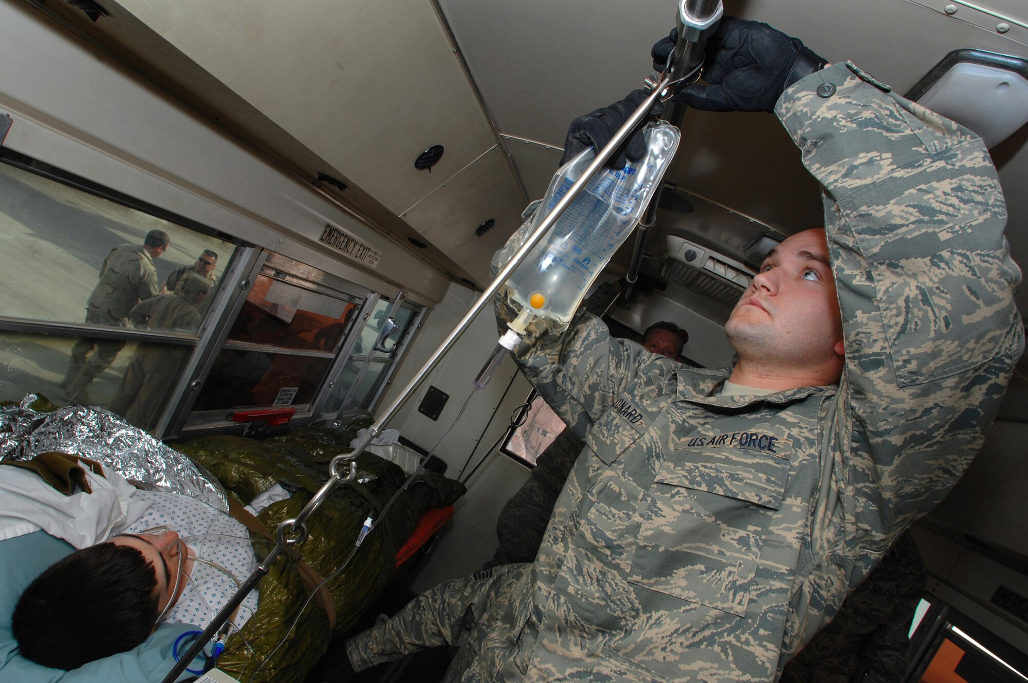 BALAD AIR BASE, Iraq -- Staff Sgt. Jason Leonard, 332nd Expeditionary Aeromedical Squadron aeromedical technician, hangs up fluids attached to a critical care patient after downloading him from a C-130 Hercules here, Feb. 27. Sergeant Leonard is deployed from the 439th Aeromedical Staging Squadron, Westover Air Reserve Base, Mass. (U.S. Air Force photo/ Senior Airman Julianne Showalter)