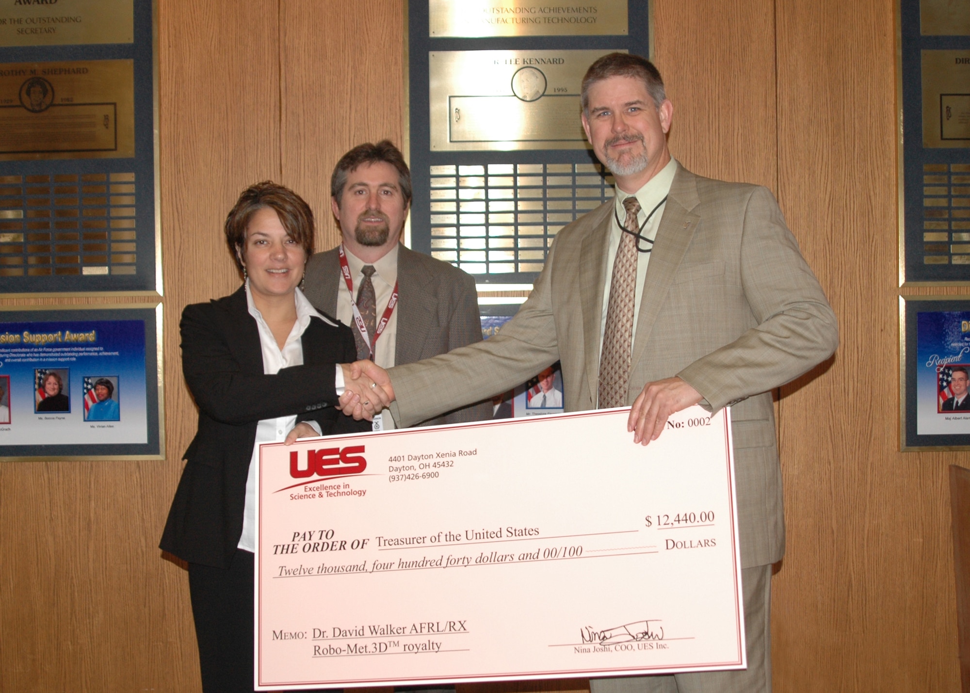 Nina Joshi, Chief Operating Officer of UES Inc., and Bryce Skinn, UES Business Relations Manager, present a royalty check for $12,440 to Dr. David Walker, Director of RX.  The royalty was based on the sale price of Robo-Met.3DTM, which was delivered to Carnegie Mellon University in February.

