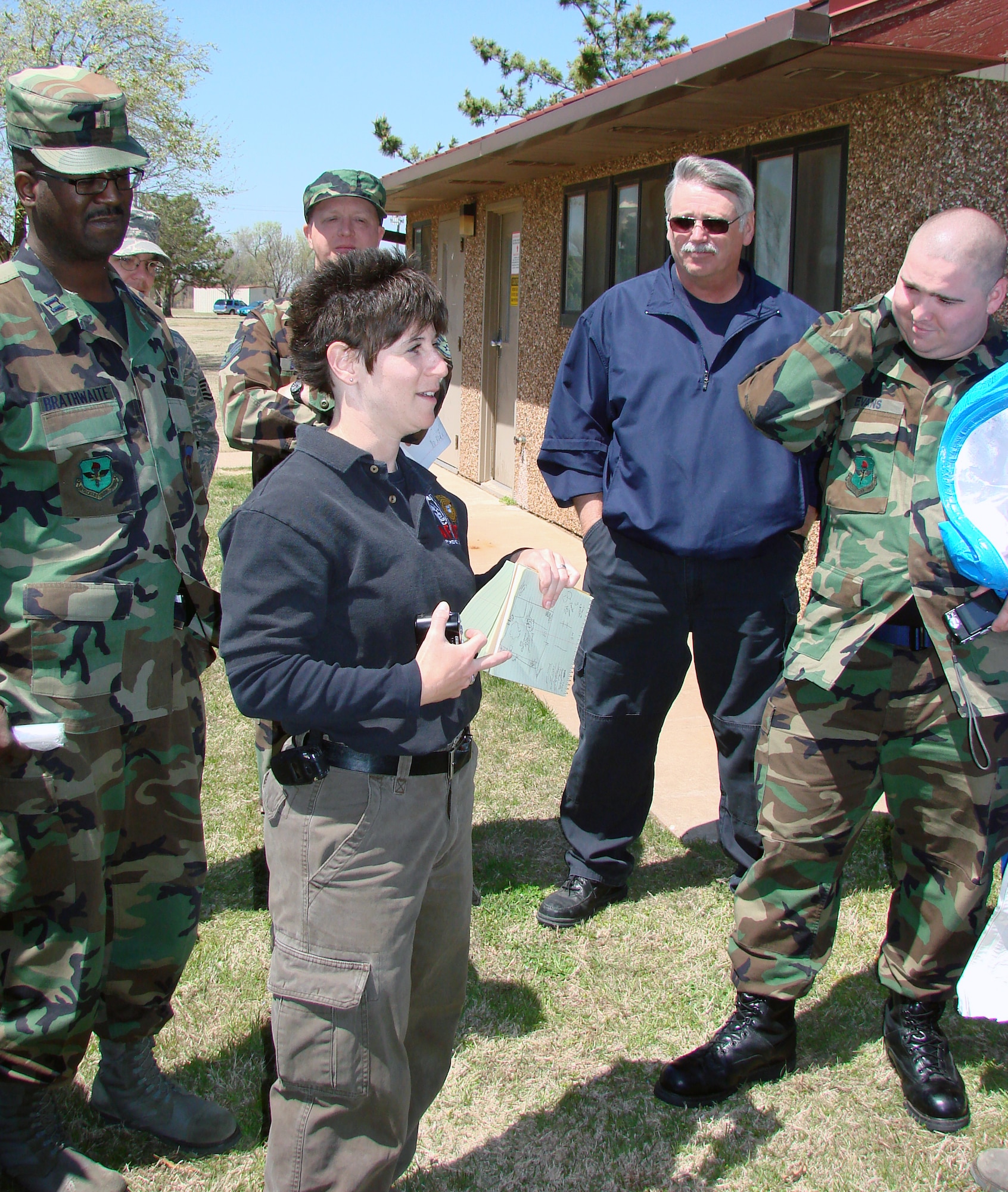 Special Agent Jennifer Steel, an AFOSI forensic science consultant, reviews the practical exercise with bioenvironmental, AFOSI, security forces and fire department people on how to preserve and process a chemical or weapon of mass destruction scene that may be a result of criminal activity during training Tuesday. (Air Force Photo by Capt. Tony Wickman)